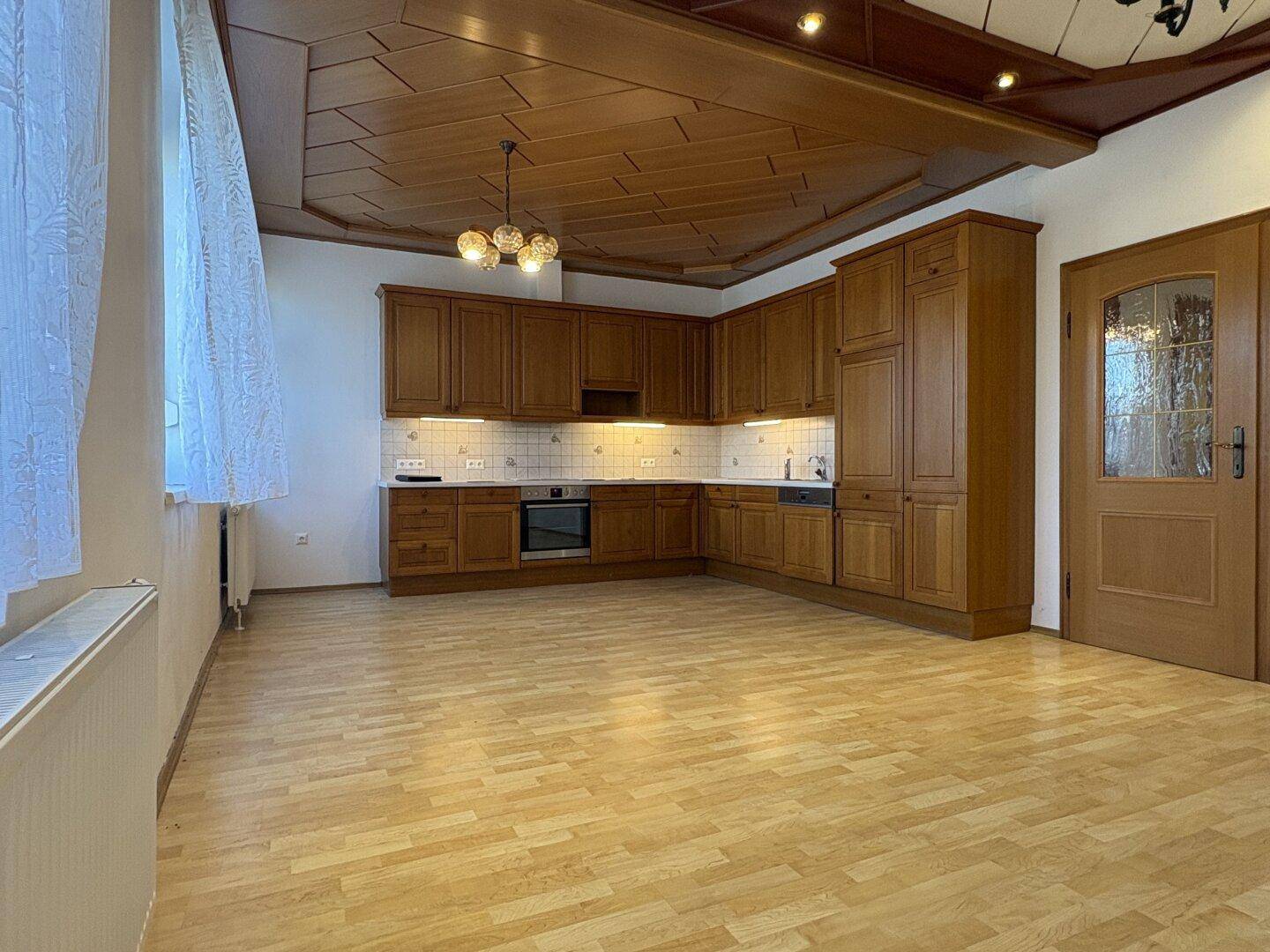 Geräumige Holzküche mit Einbauschränken und hellem Holzboden, ideal für Familien.