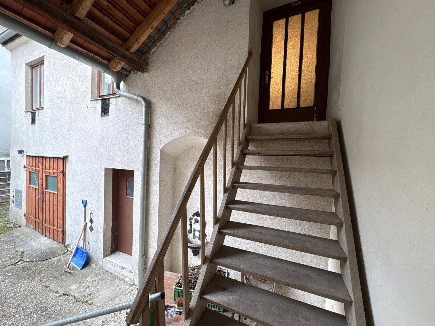 Außentreppe führt zu einer oberen Etage, umgeben von der Gebäudefassade.