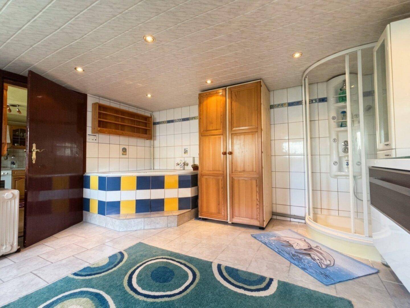 Badezimmer mit farbenfroher Eckbadewanne und separater Duschkabine, bietet Komfort.