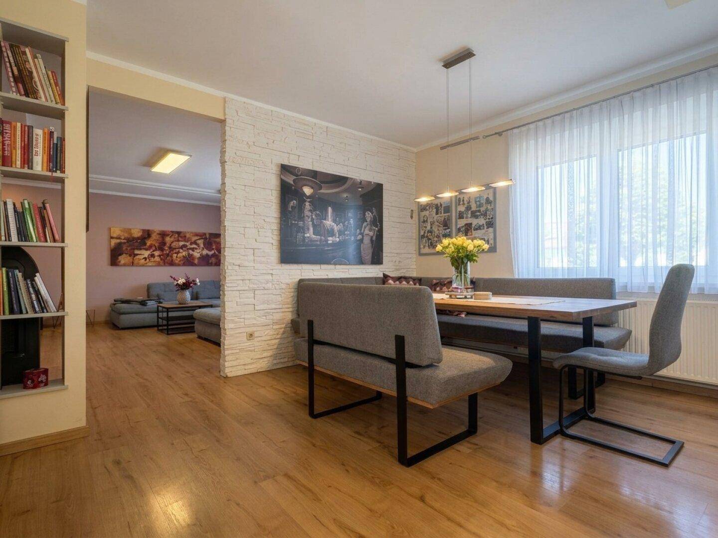 Offener Wohn- und Essbereich mit Holzboden, Esstisch und Blick ins Wohnzimmer.