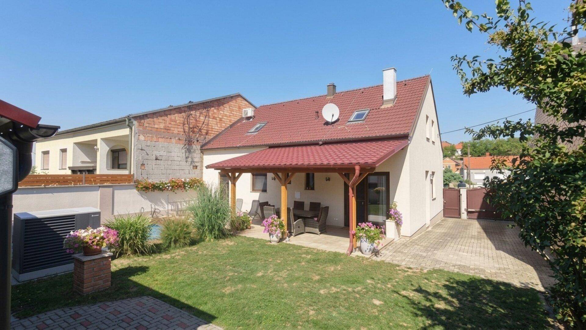 Ansicht des Hauses von hinten mit Garten, Terrasse und Poolbereich.