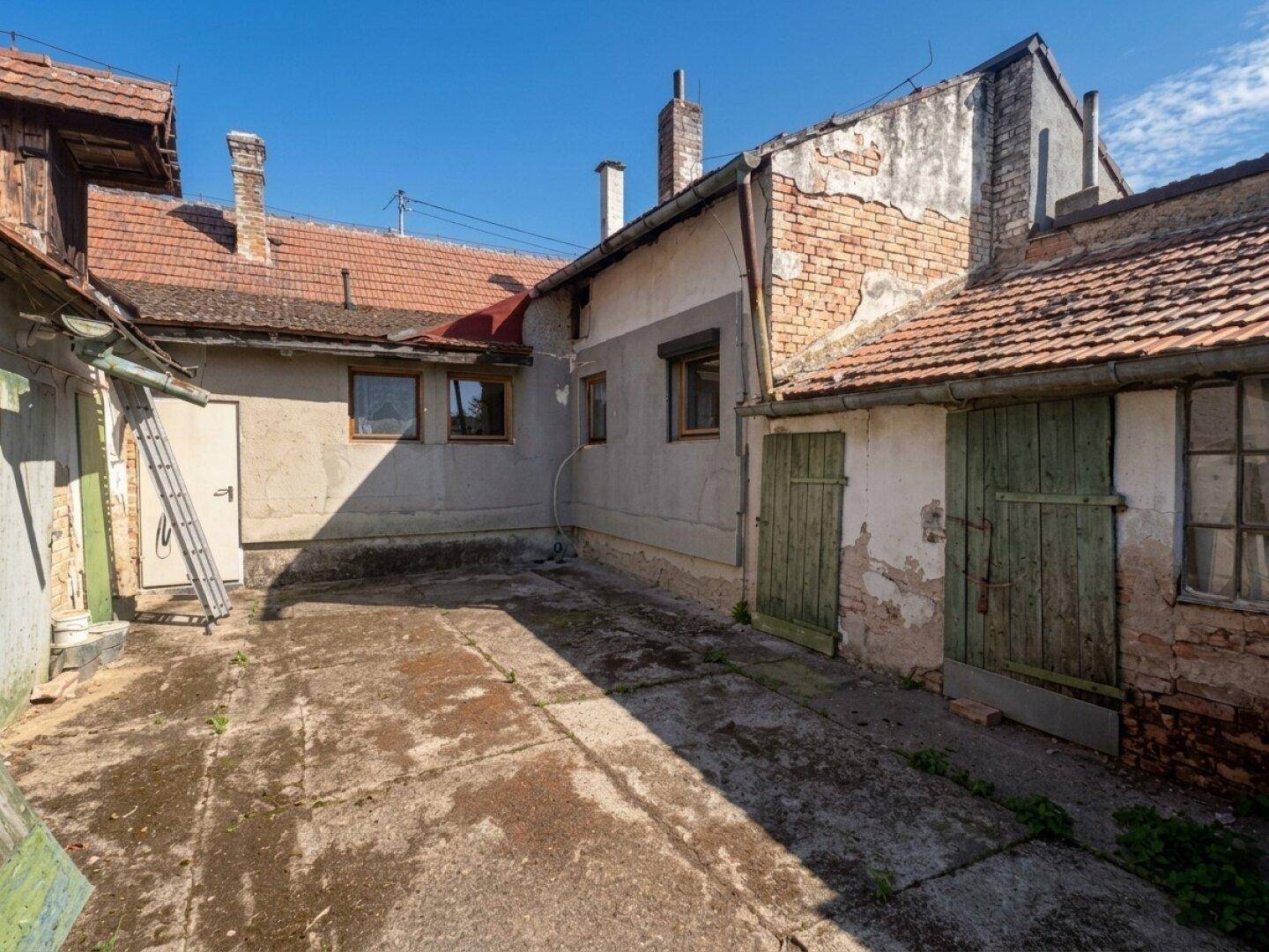 Innenhof des Anwesens, umgeben von alten Gebäuden mit Ziegel- und Putzfassaden.