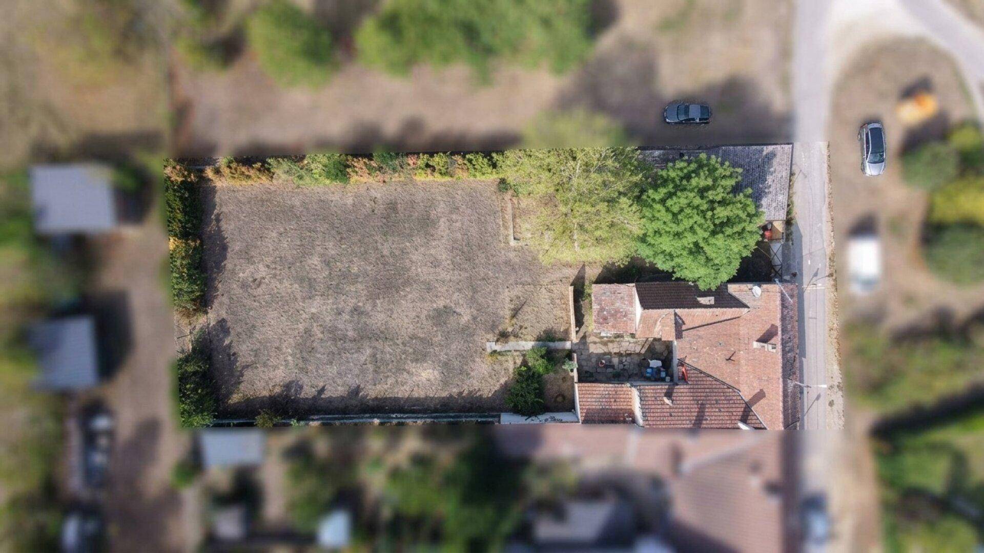 Luftaufnahme des Grundstücks mit Haus, Nebengebäuden und dem großen Feld.