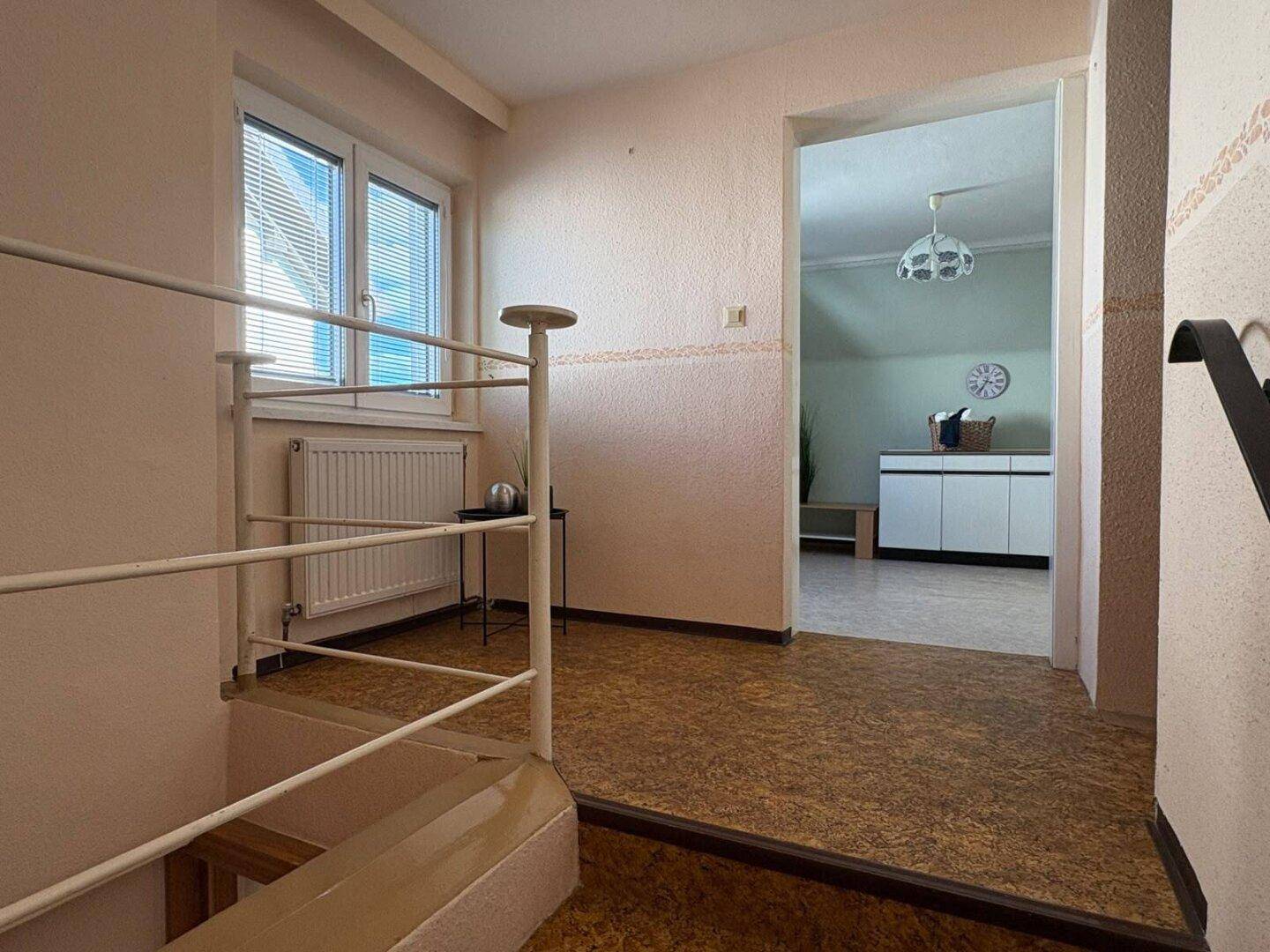 Heller Flur mit Treppenaufgang und Zugang zu weiteren Zimmern im Obergeschoss, gut beleuchtet.