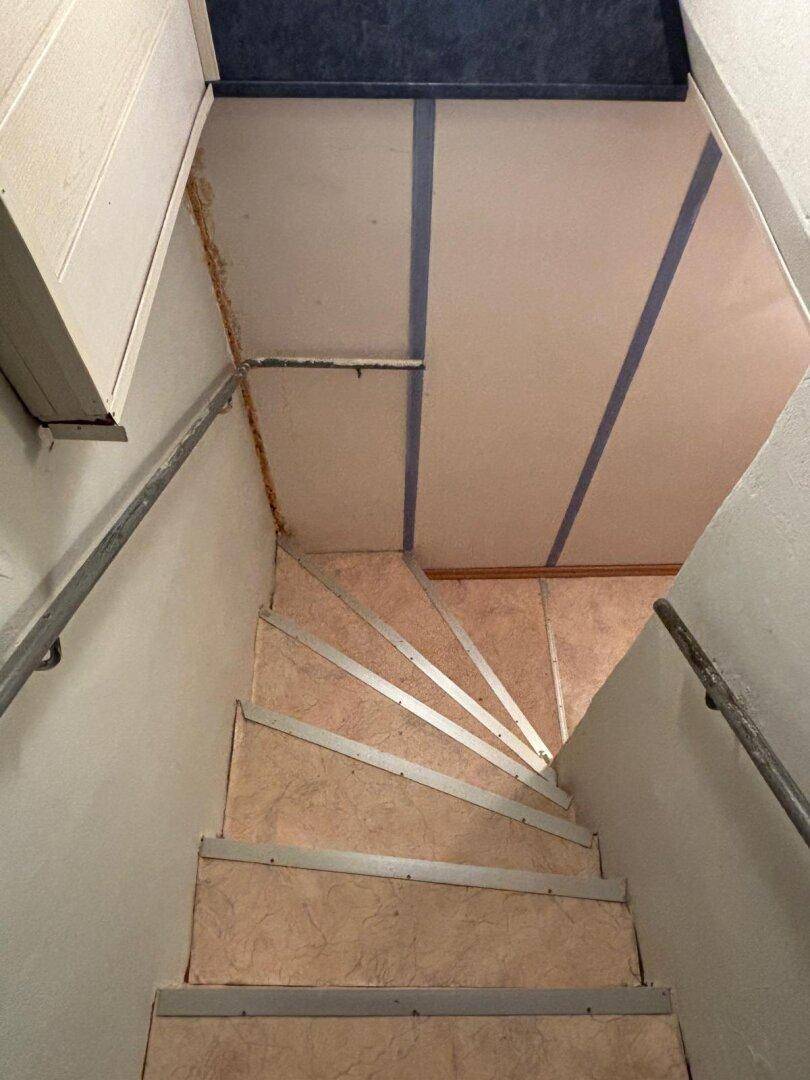 Treppenabgang mit Handlauf, der in den unteren Bereich des Hauses führt.