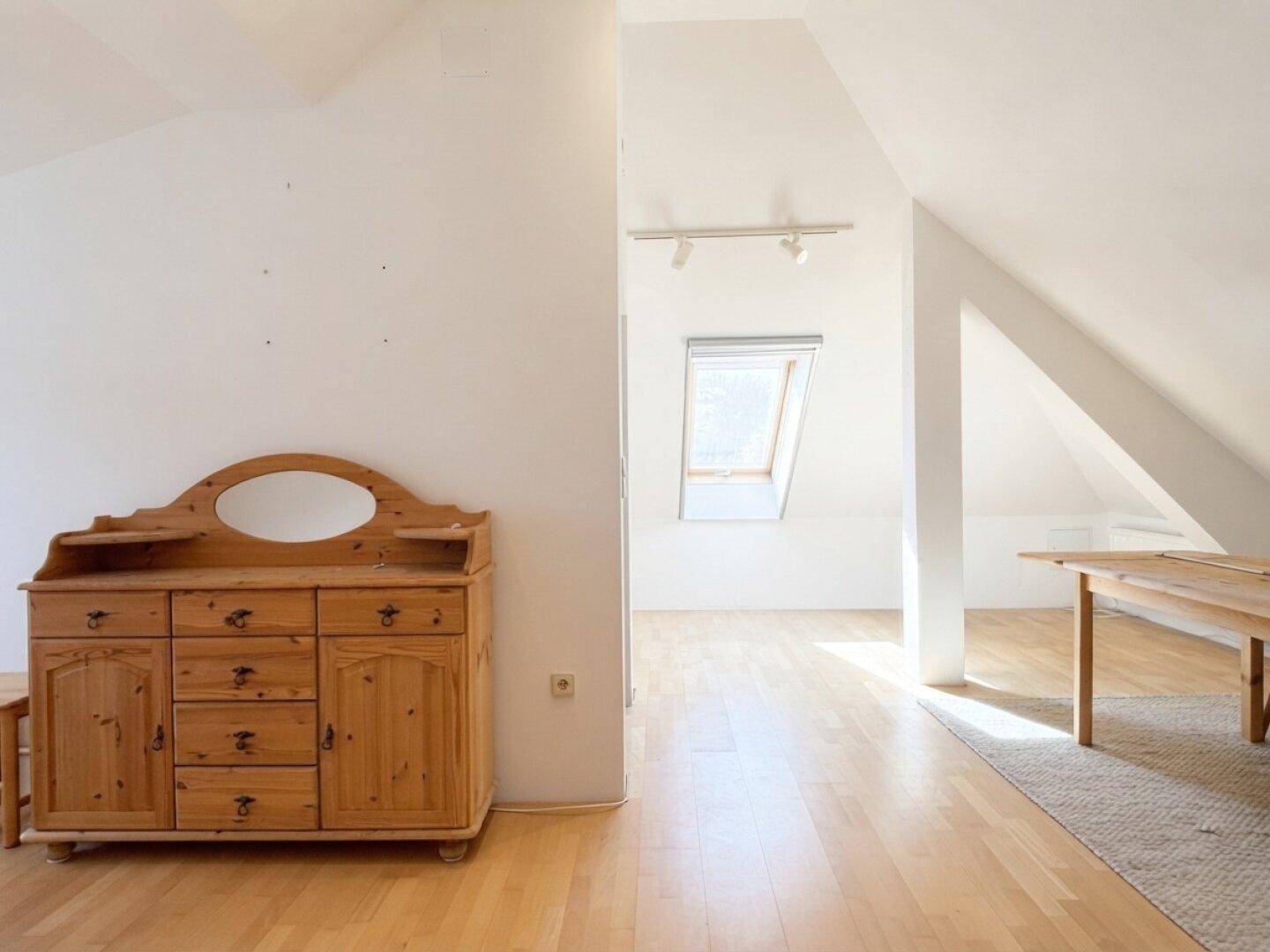 Heller Dachbodenraum mit Holzboden, Dachfenster und schrägen Wänden, vielseitig nutzbar.