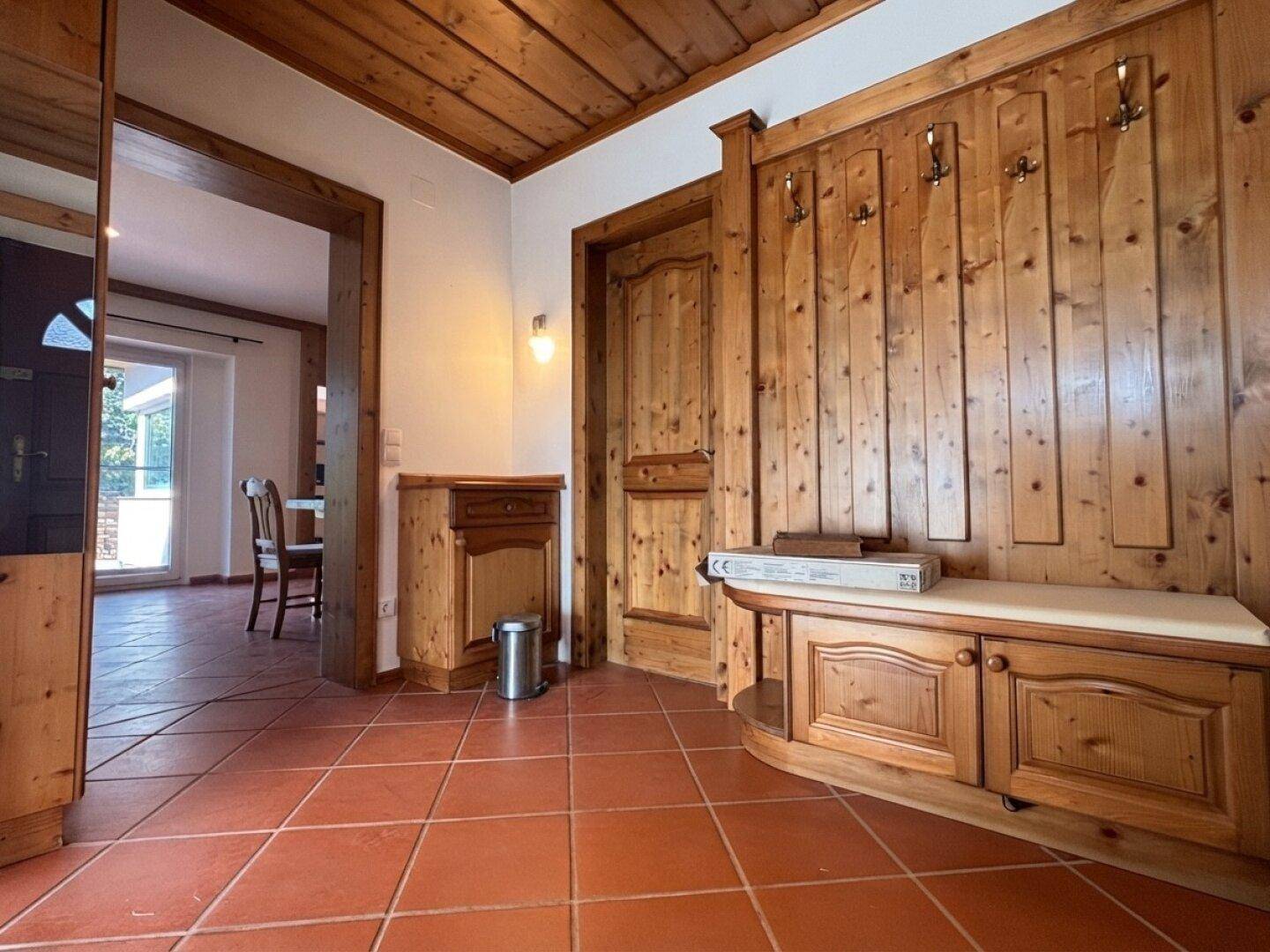 Gemütlicher Flur mit Holztäfelung, integrierter Garderobe und Zugang zu weiteren Räumen.