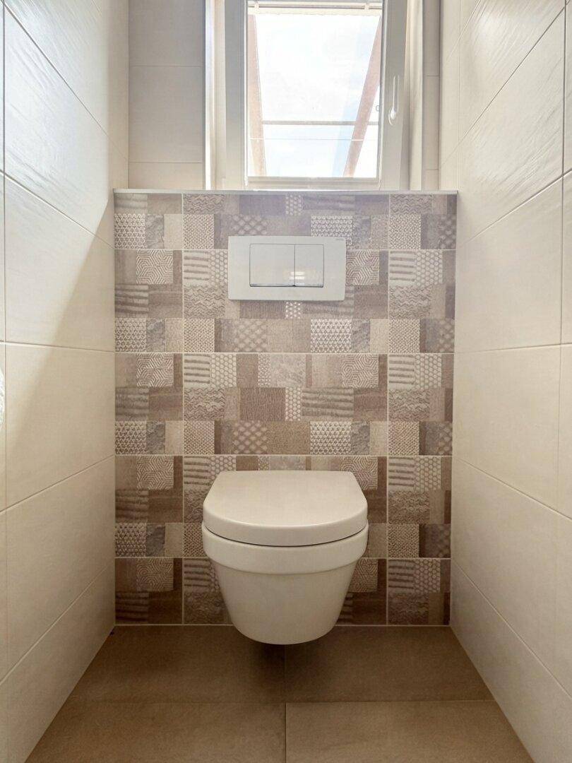 Modernes Gäste-WC mit Wand-WC, gemusterten Fliesen und kleinem Fenster für Tageslicht.