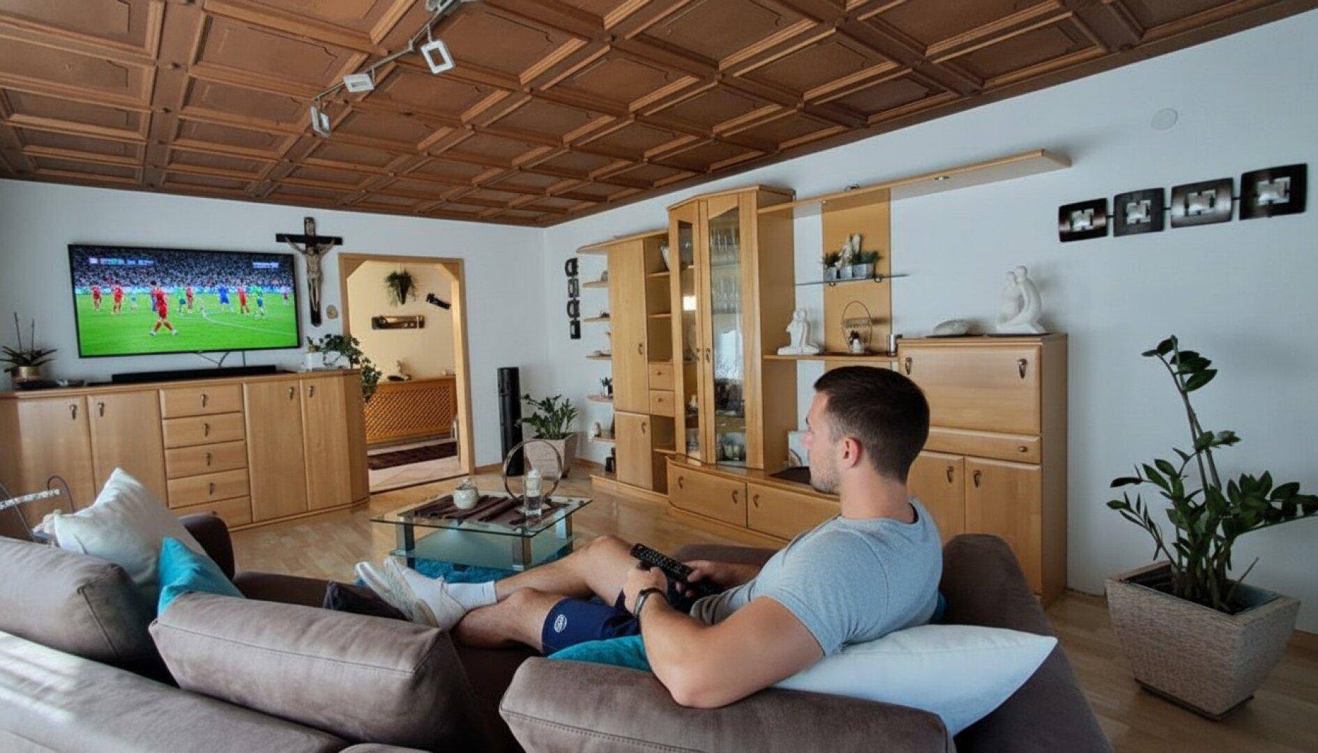 Gemütliches Wohnzimmer mit Holzkassettendecke, Parkettboden und traditionellen Holzmöbeln.