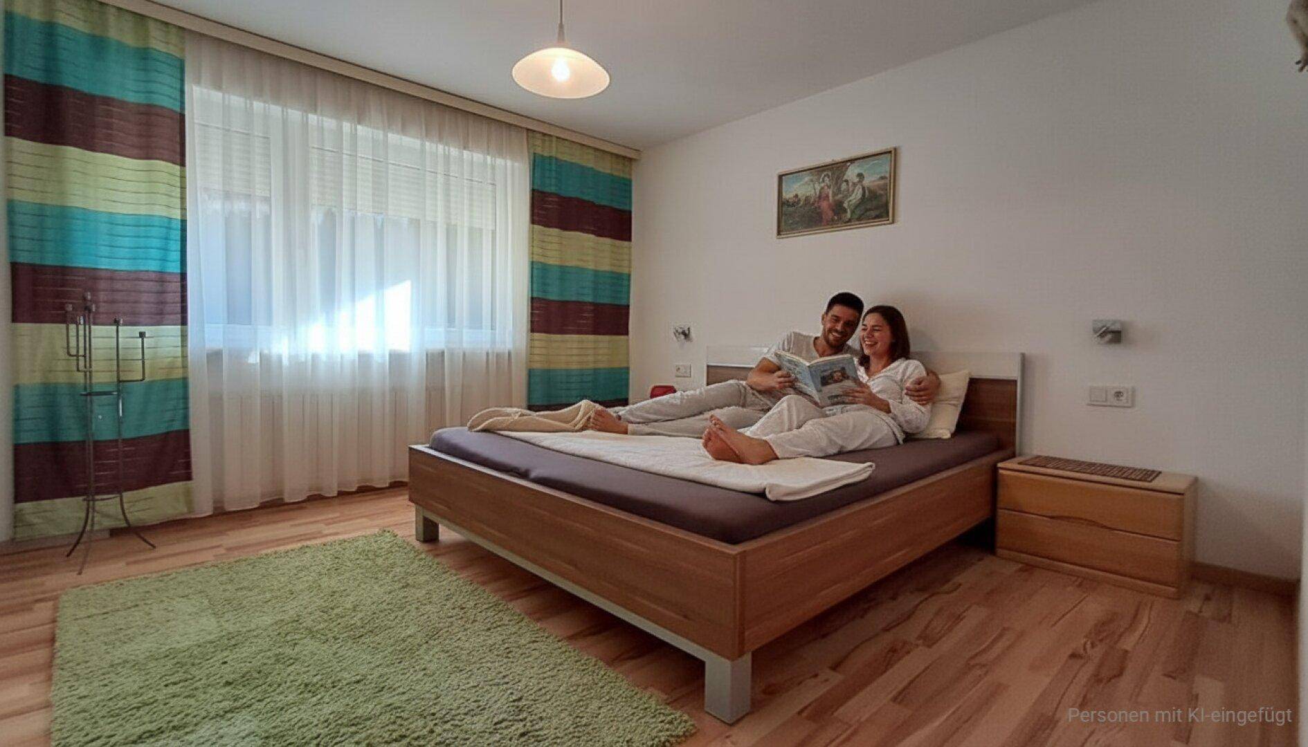 Gemütliches Schlafzimmer mit Holzboden, Doppelbett und farbenfrohen Vorhängen.