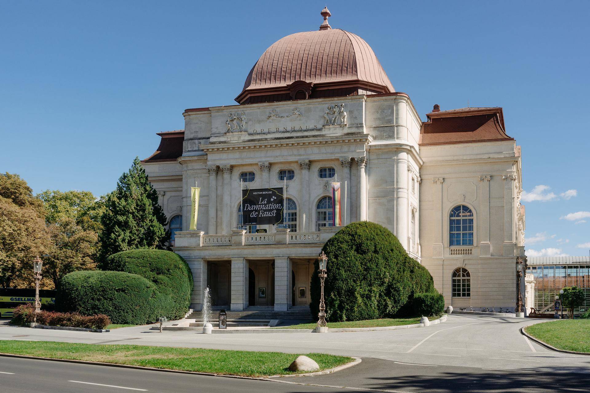 Prächtiges historisches Gebäude mit Kuppeldach und gepflegter Grünanlage.