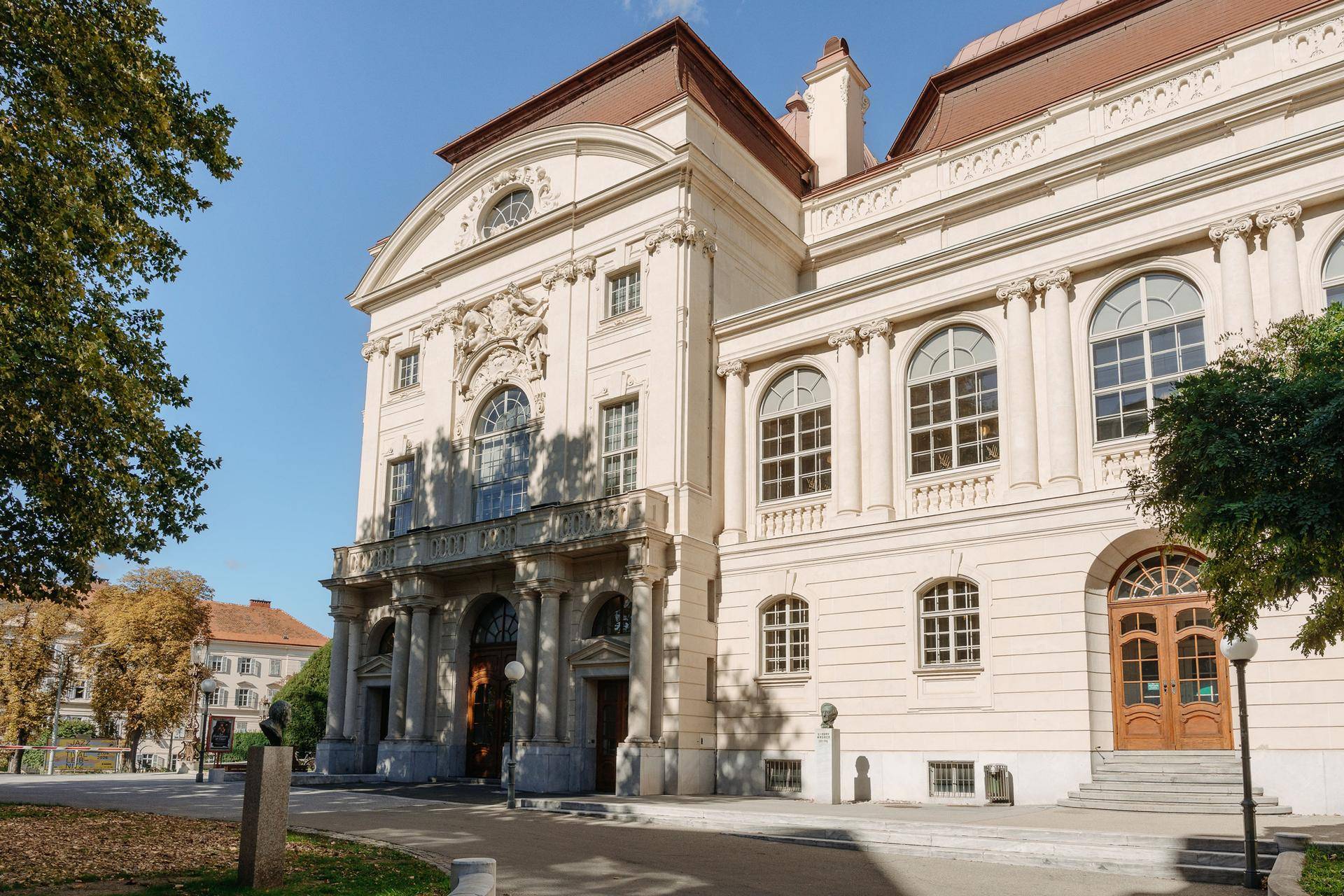 Detailansicht der eleganten Fassade eines historischen Gebäudes mit Säulen und Bögen.