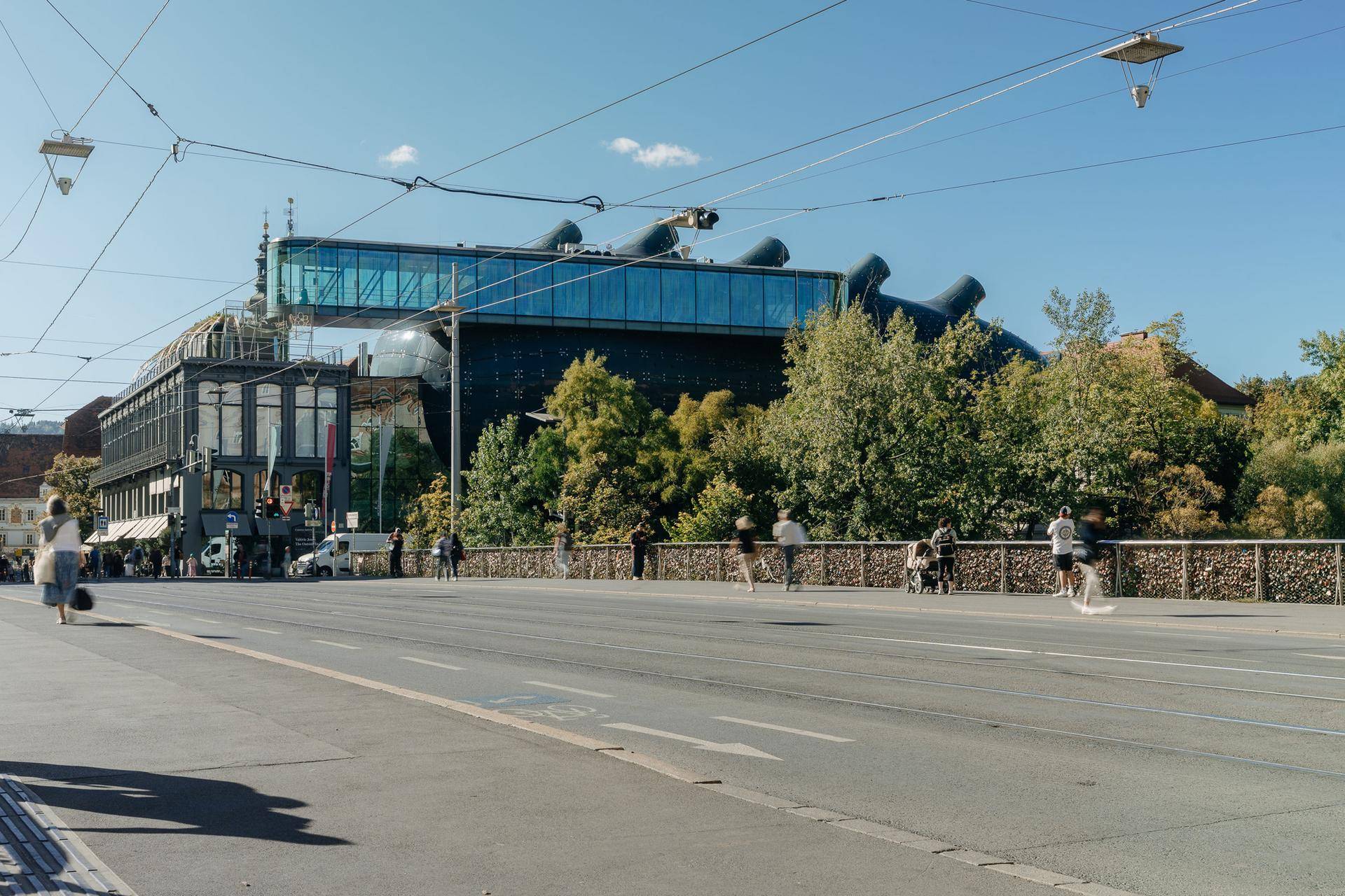 Moderne Architektur mit Glasfassade an einer Brücke in der städtischen Umgebung.
