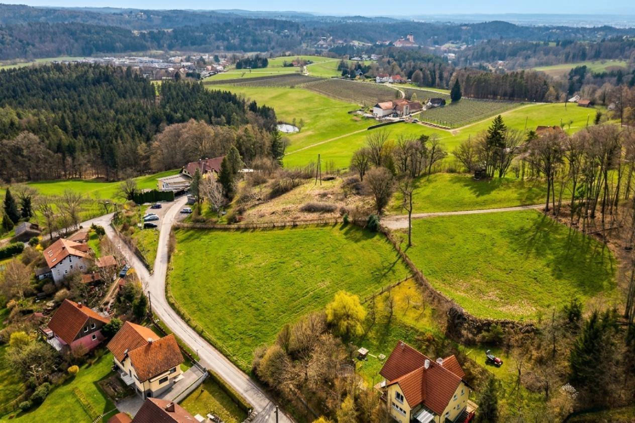 Weitläufige Luftaufnahme einer ländlichen Gegend mit Feldern, Wäldern und vereinzelten Wohnhäusern.