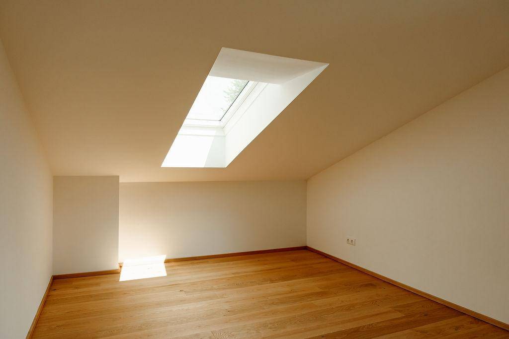 Heller Raum mit Holzboden und Dachfenster, das viel natürliches Licht spendet.