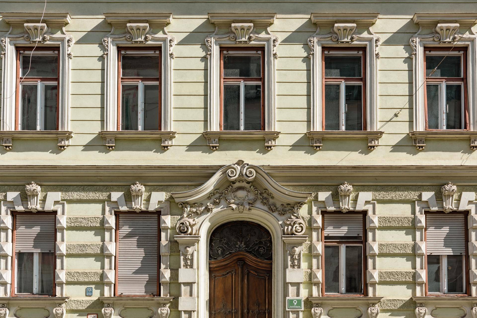 Detailansicht der historischen Fassade mit verzierten Fenstern und dem Eingangsportal.