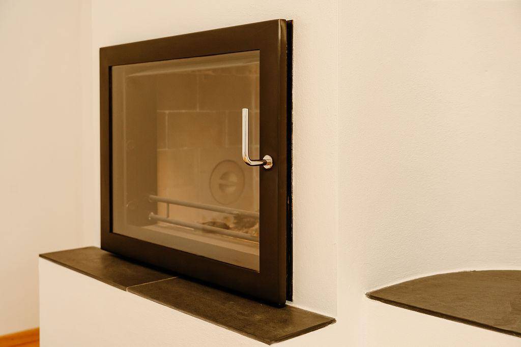 Detailansicht des modernen Kamineinsatzes mit schwarzem Rahmen und Glasfront.