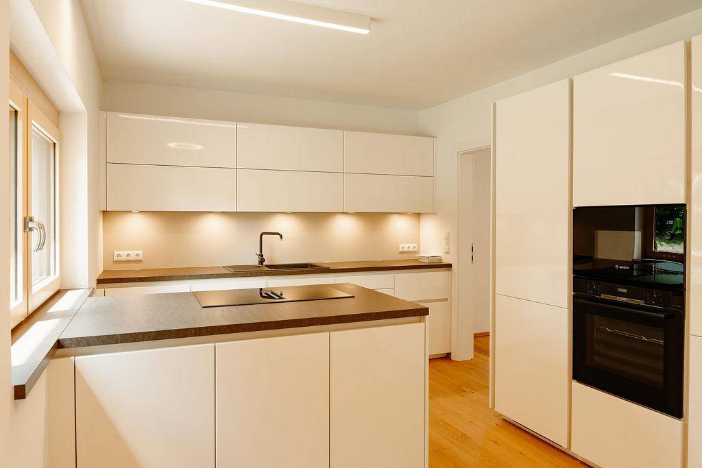 Helle, moderne Küche mit integrierten Geräten und viel Stauraum für kulinarische Erlebnisse.