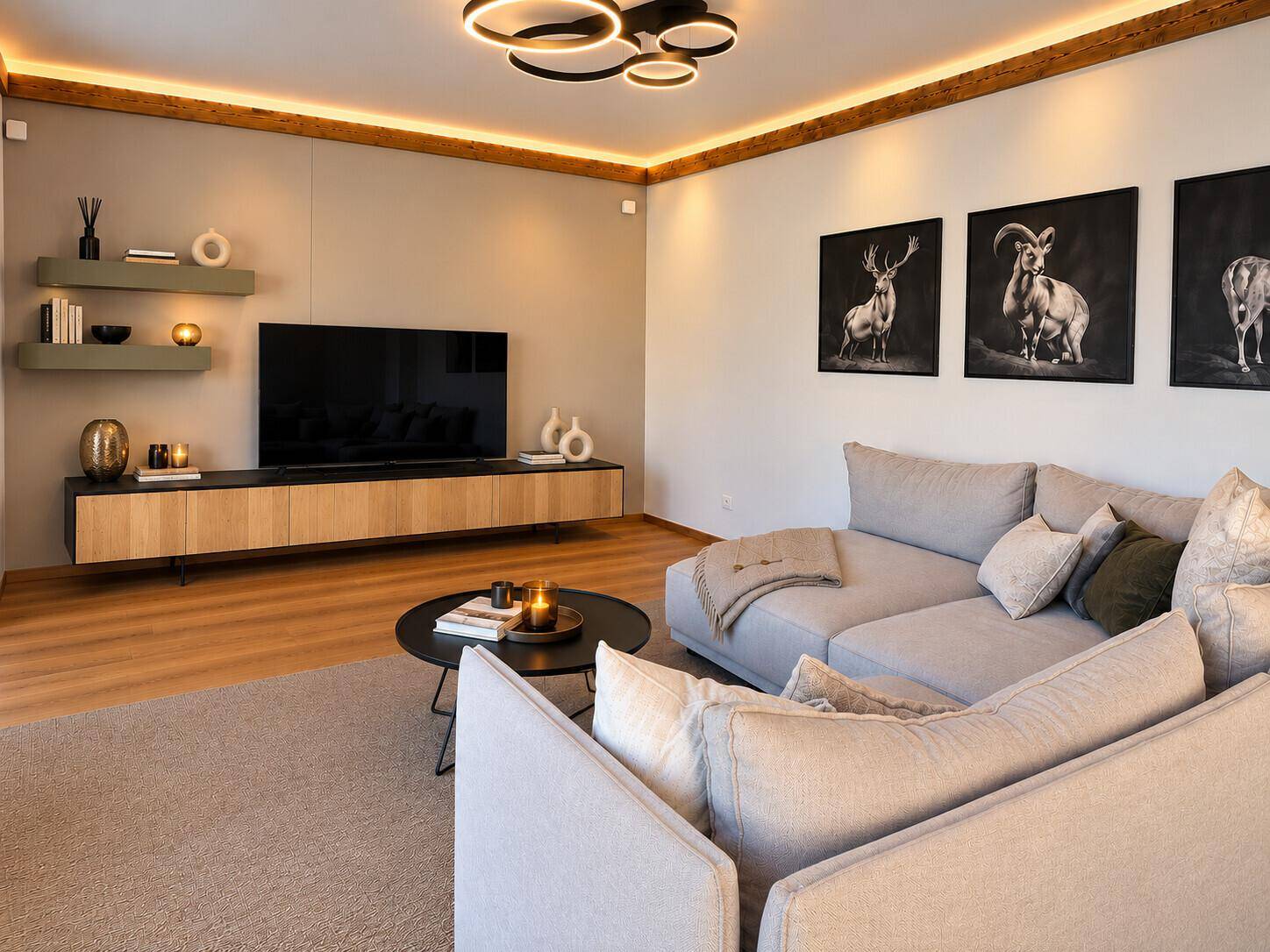 Gemütliches Wohnzimmer mit großem Sofa, modernem TV-Möbel und indirekter Beleuchtung.