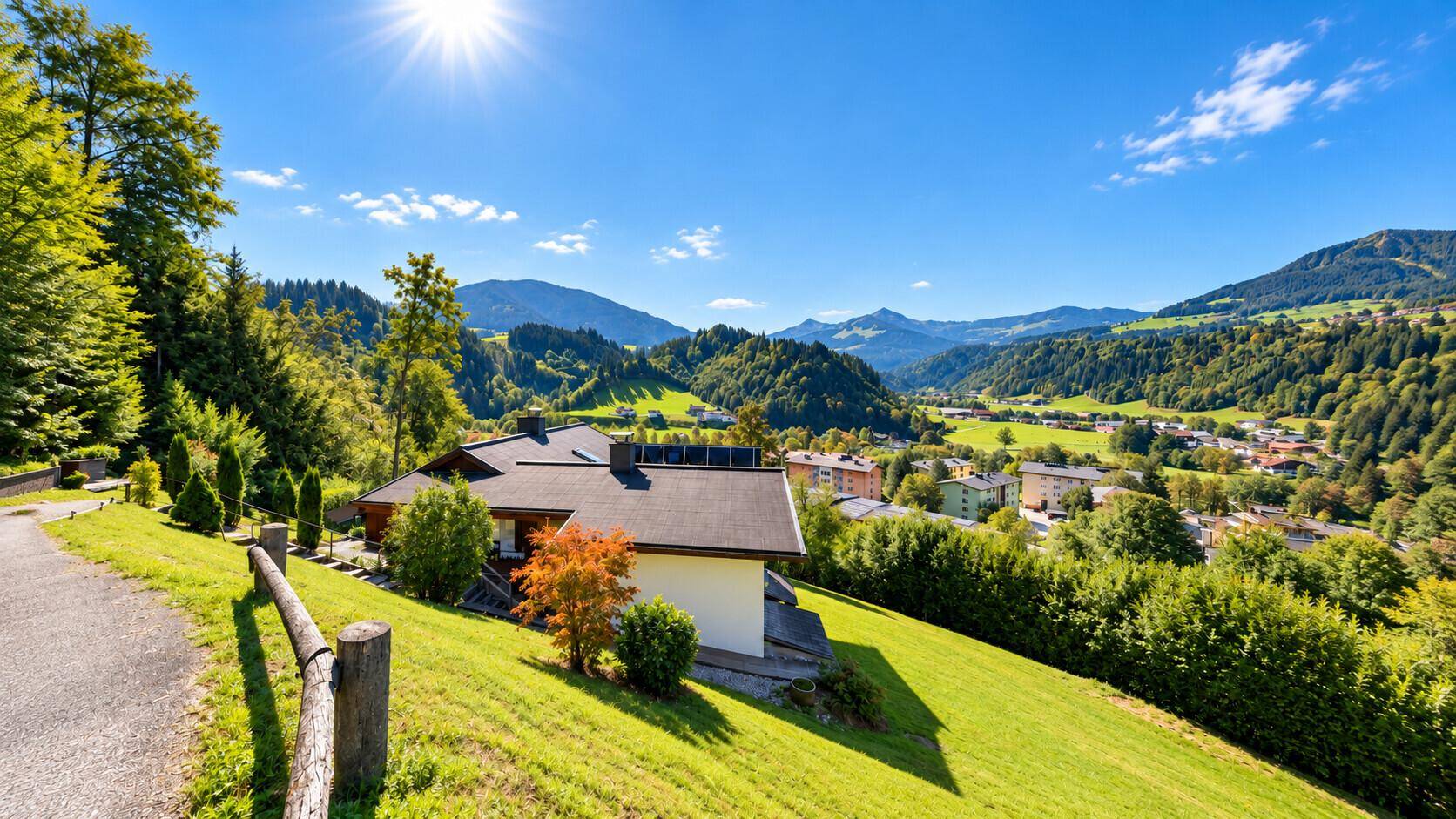 Panoramablick auf das Haus in den Bergen mit weitem Talblick unter blauem Himmel.