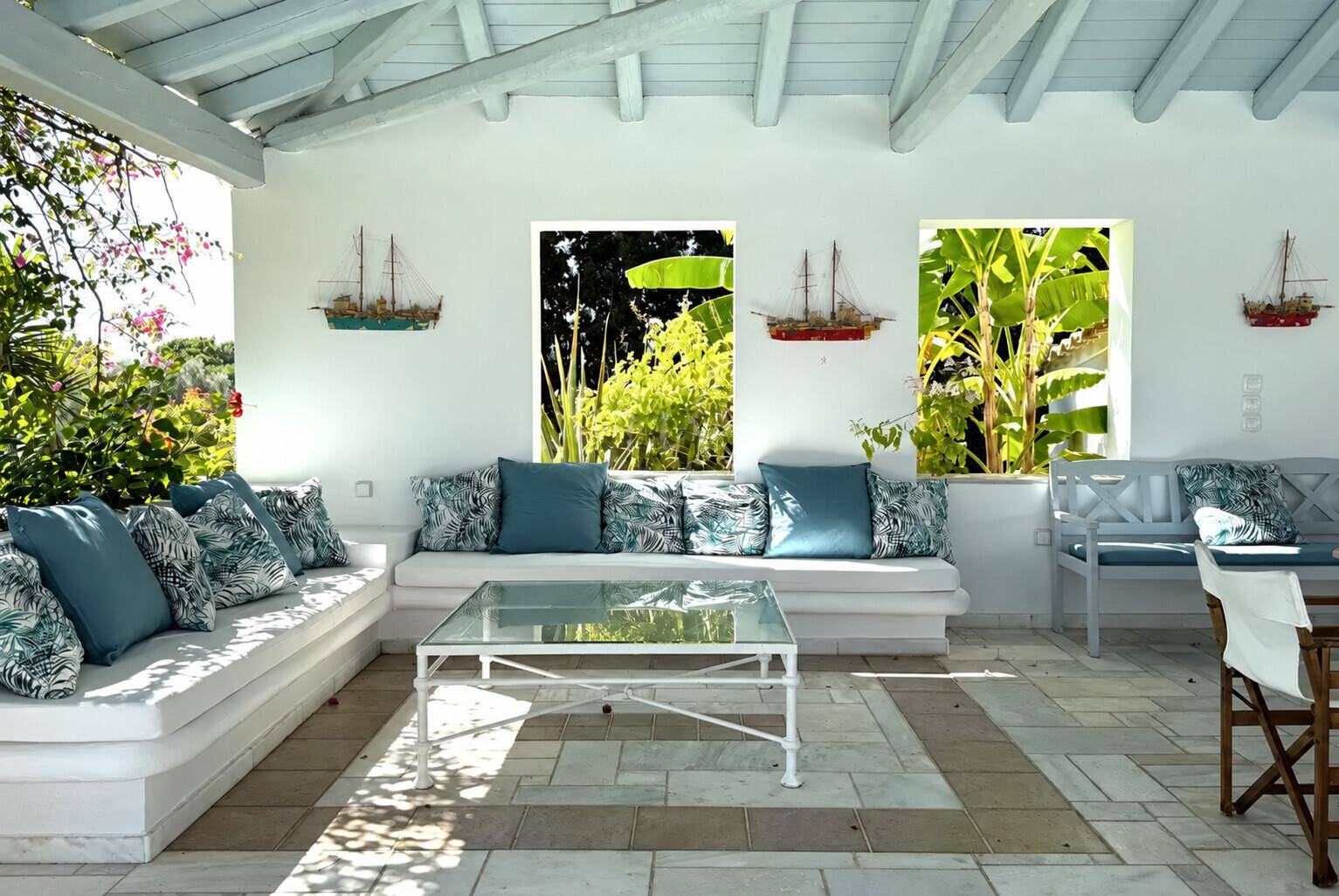 Gemütlicher überdachter Loungebereich mit bequemen Sofas und Blick auf die üppige Vegetation.