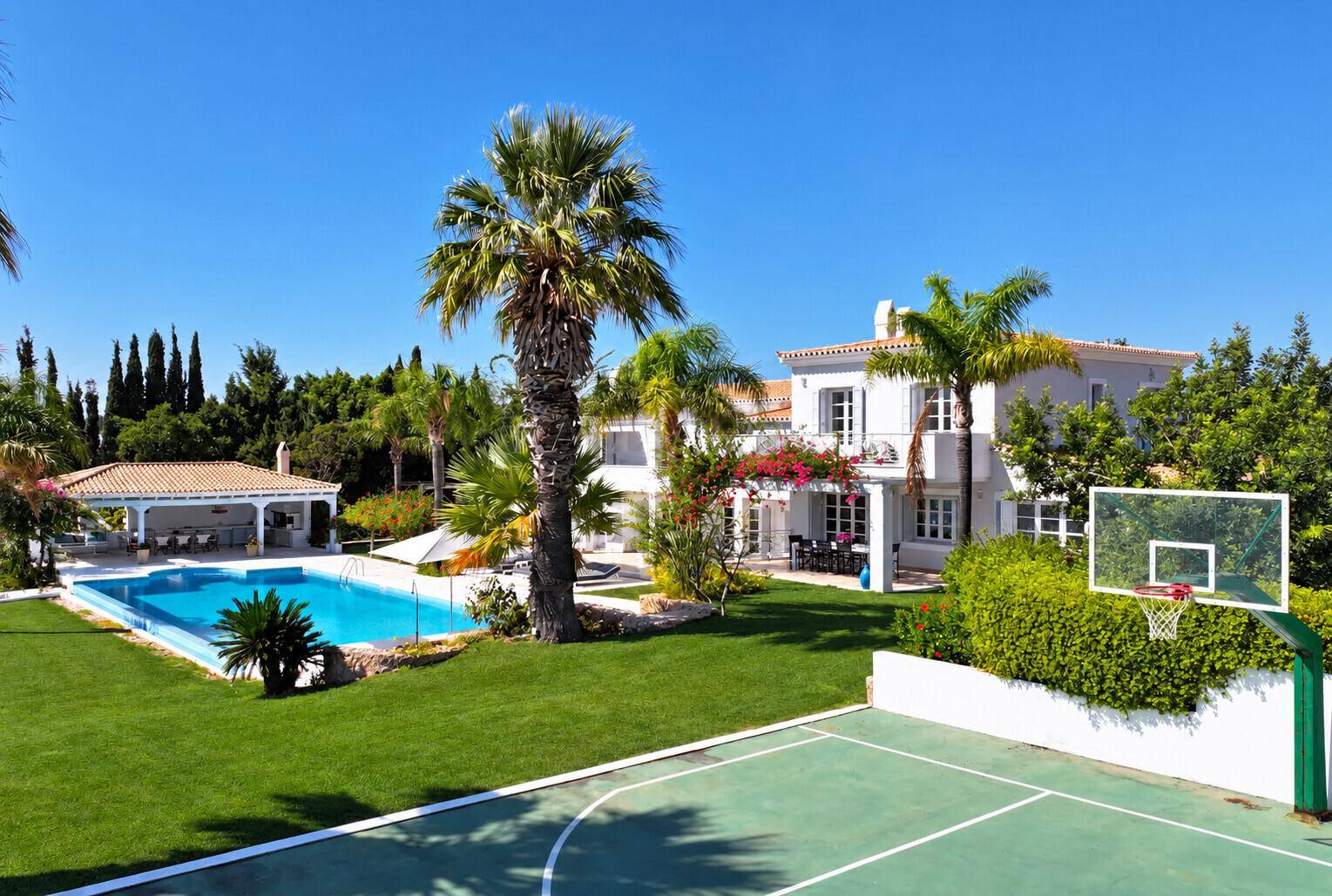 Luxuriöses Anwesen mit weitläufigem Garten, großem Pool, Basketballplatz und eleganter Villa.