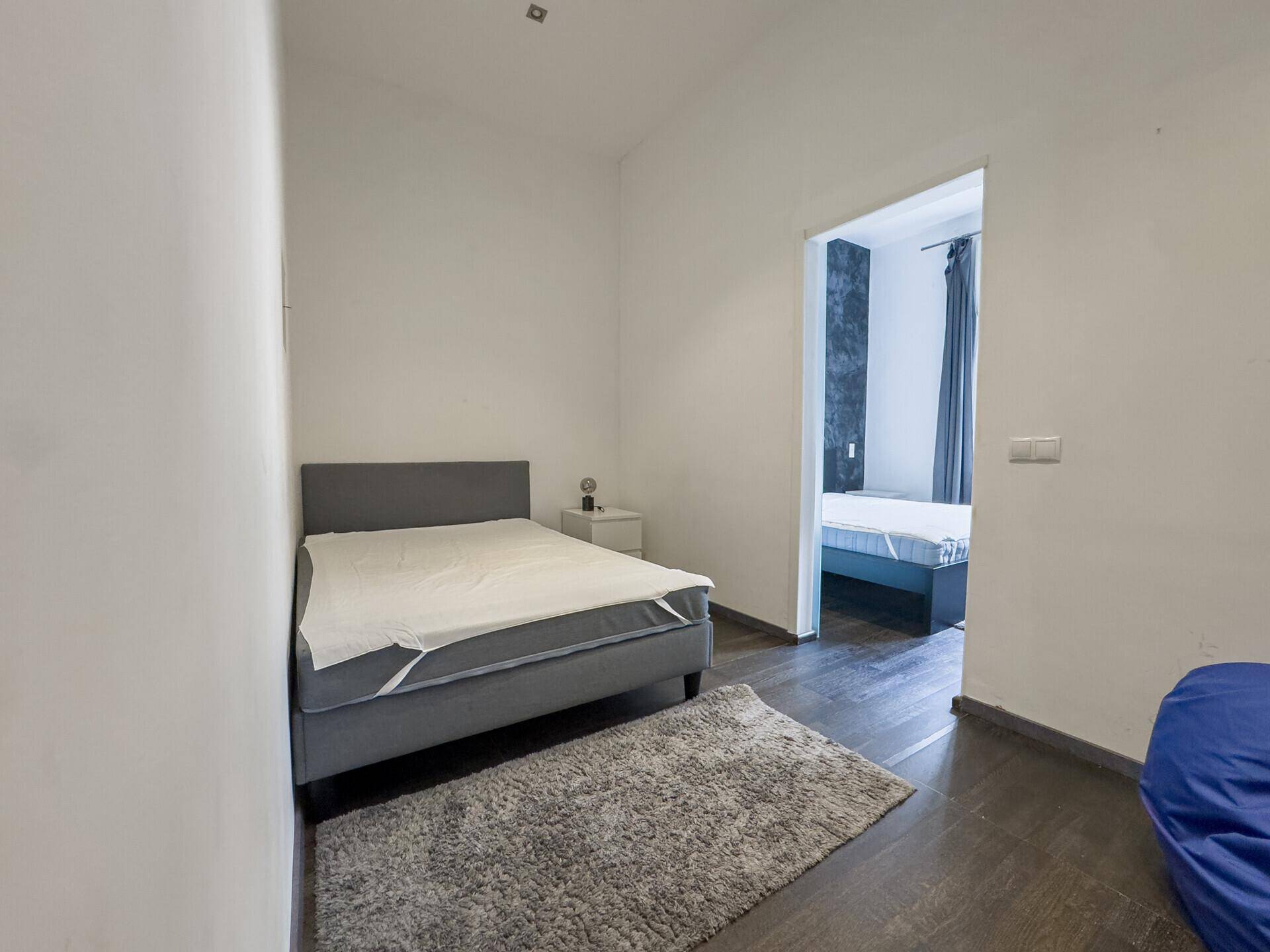 Kleines Schlafzimmer mit Einzelbett und Zugang zu einem weiteren Raum, ideal als Gästezimmer.