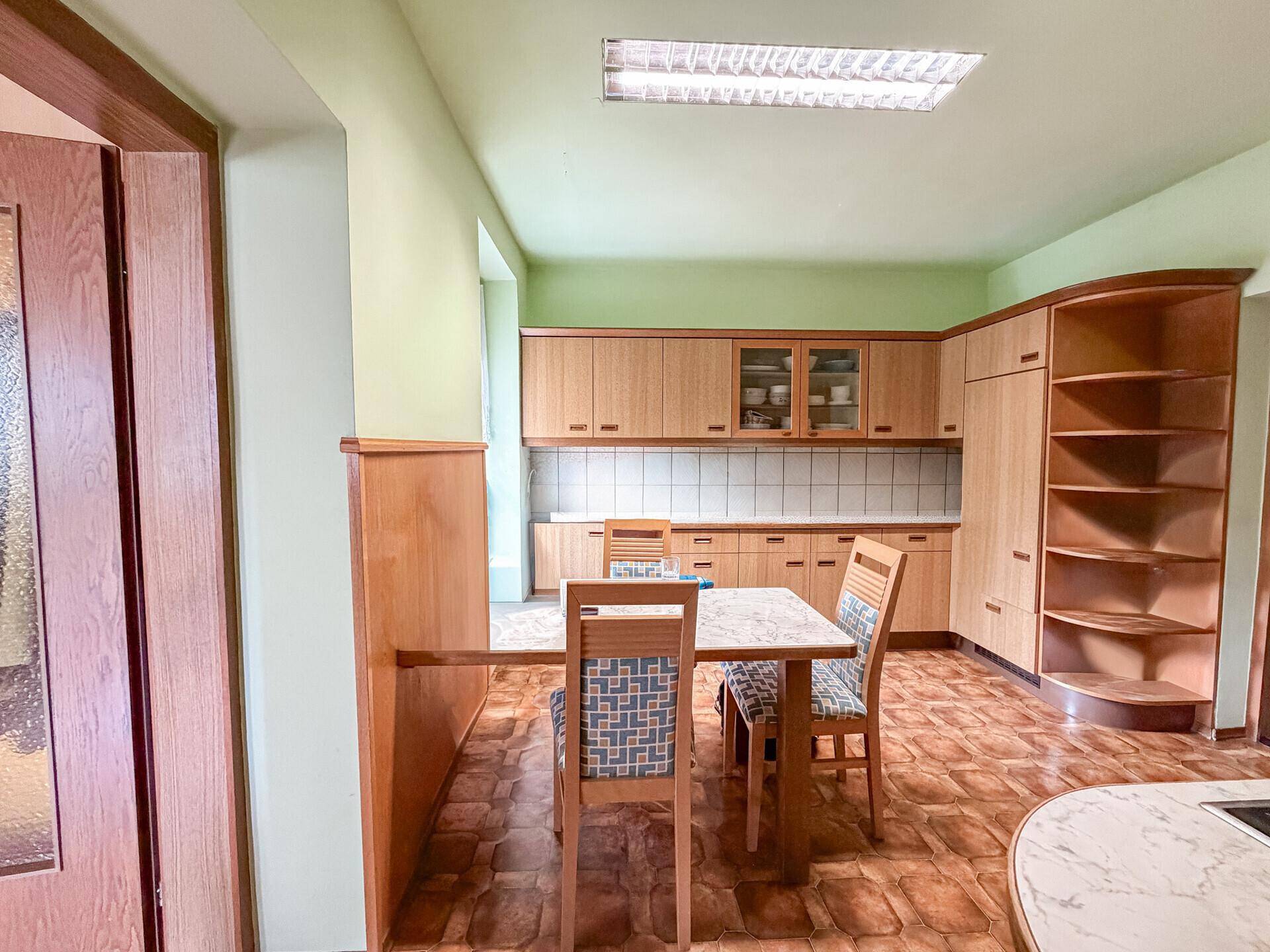 Geräumige Küche mit Essbereich, Holzmöbeln und viel Stauraum in den Schränken.