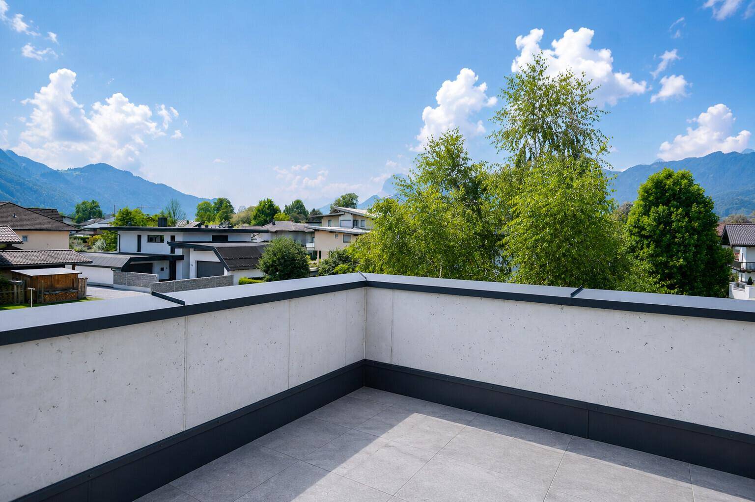 Geräumige Dachterrasse mit Fliesenboden und weitem Blick auf die umliegende Berglandschaft.
