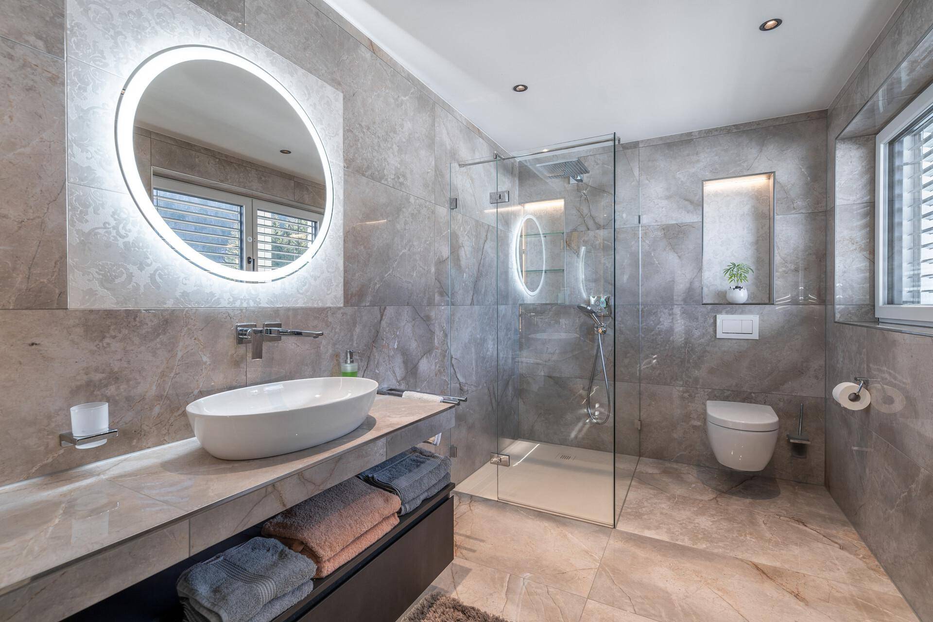 Modernes Badezimmer mit begehbarer Dusche, Einzelwaschbecken und Fenster für Tageslicht.