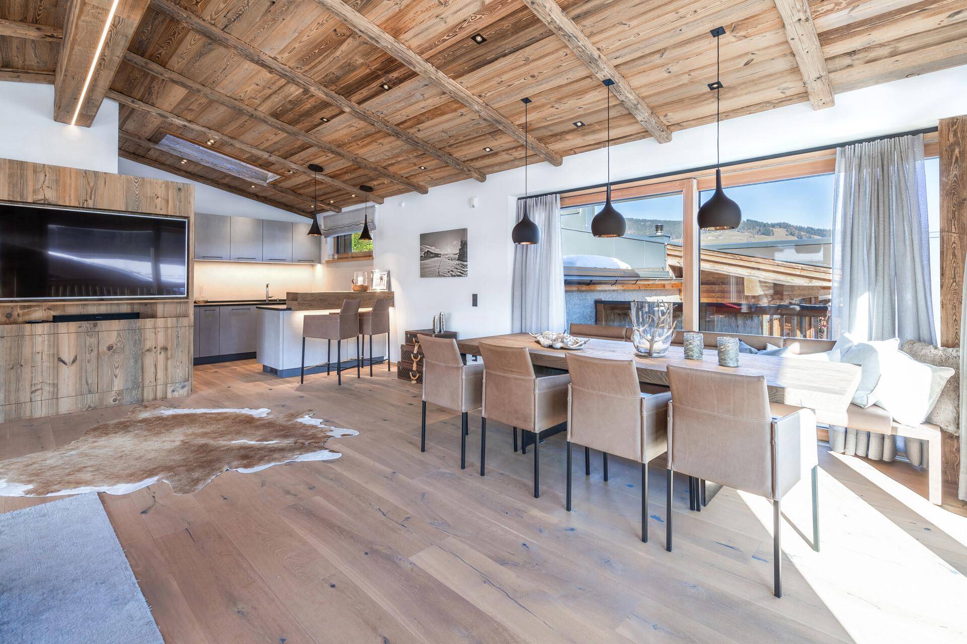 Offene Küche mit Essbereich, Frühstücksbar und Zugang zu einem Balkon mit Bergblick.