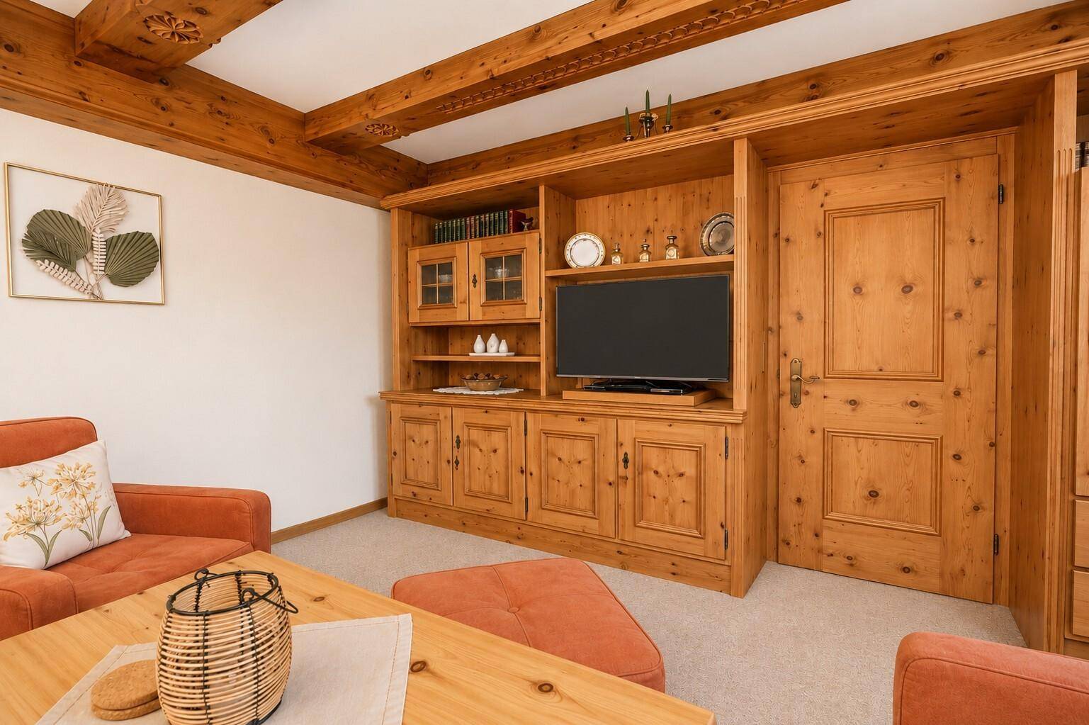 Gemütliches Wohnzimmer mit Holzbalkendecke, Einbauschrank und traditionellen Holzmöbeln.