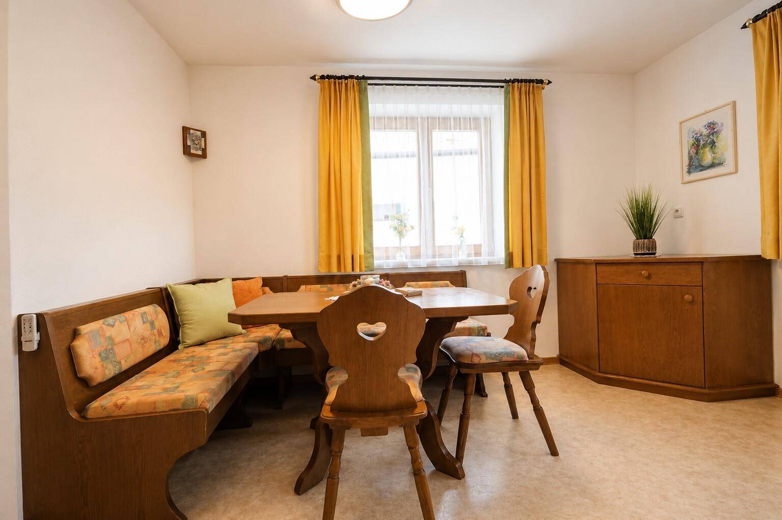 Gemütlicher Essbereich im Landhausstil mit Eckbank, Holztisch und Blick ins Grüne.