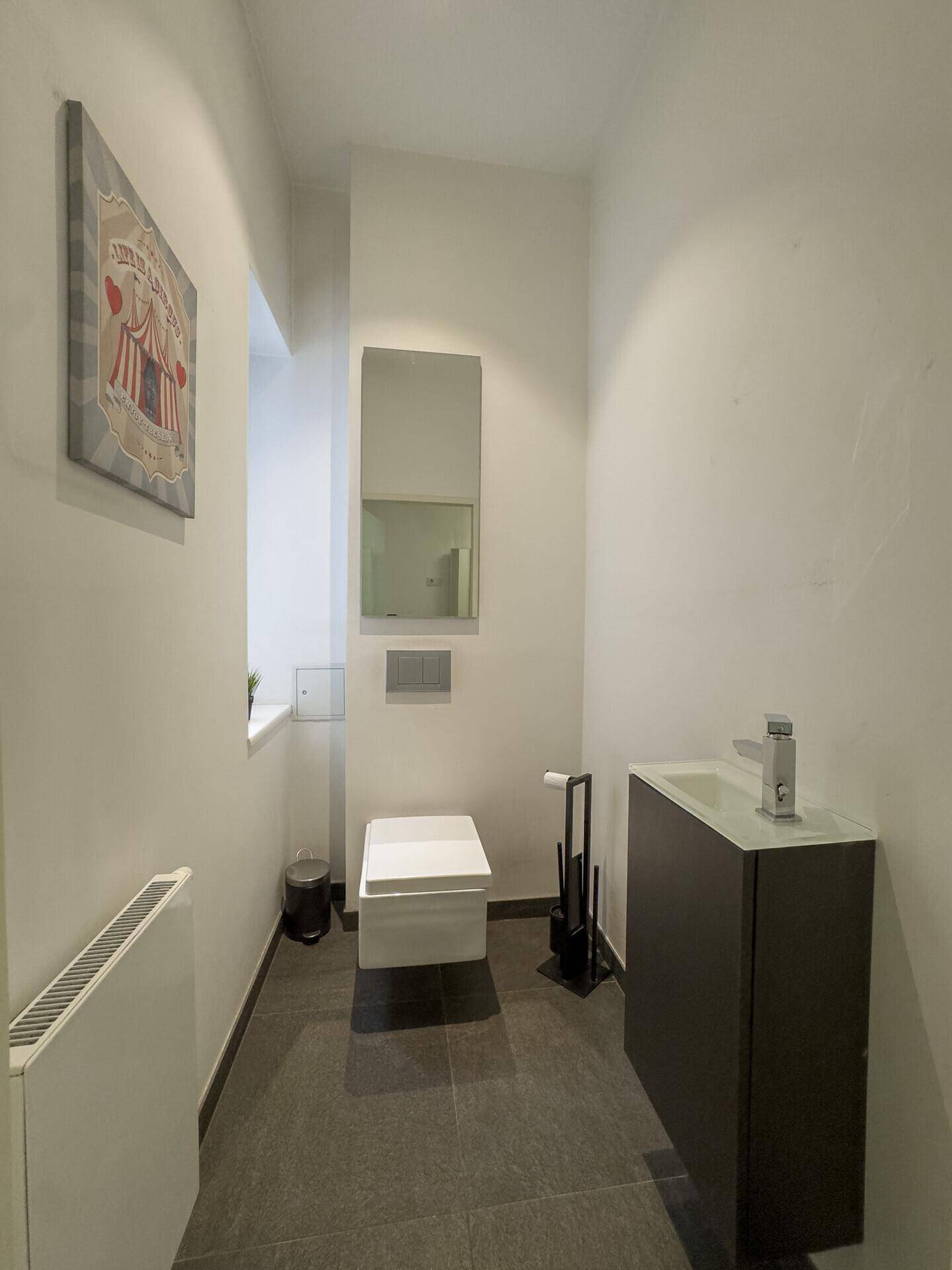 Kleines Gäste-WC mit wandhängender Toilette, Waschbecken und modernem Design.