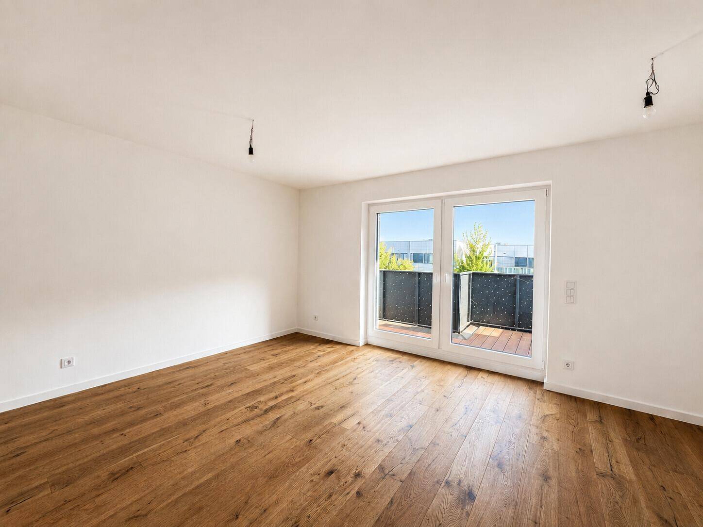 Geräumiges Zimmer mit Holzboden und direktem Zugang zum Balkon, bereit zur individuellen Gestaltung.