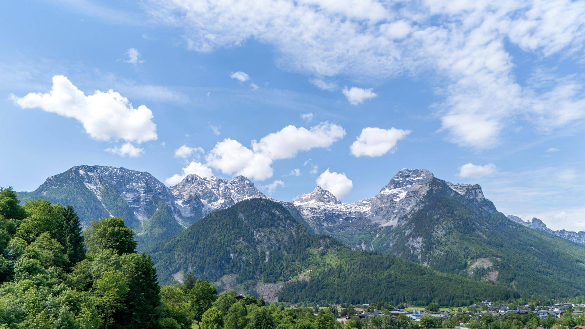 Panoramablick auf majestätische, schneebedeckte Berge unter blauem Himmel.