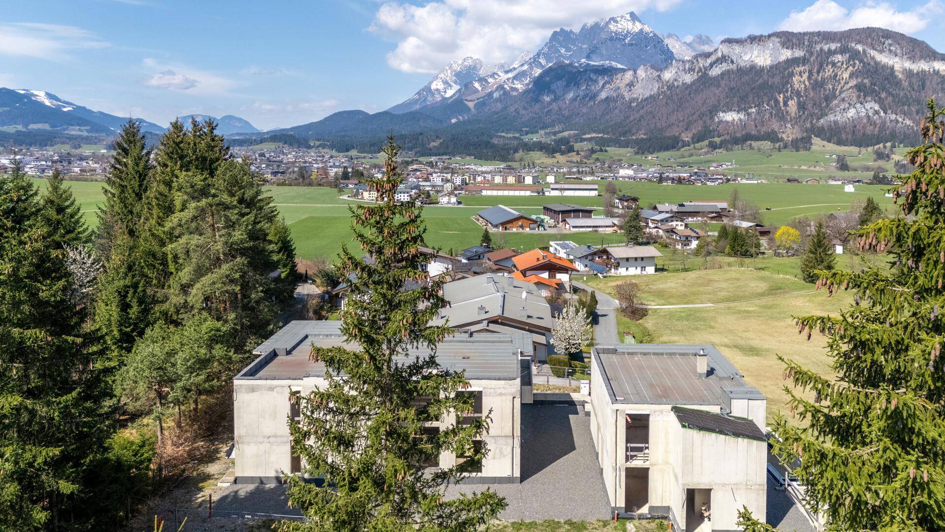 Luftaufnahme des Gebäudes in ländlicher Umgebung mit Blick auf eine Stadt und die Berge.