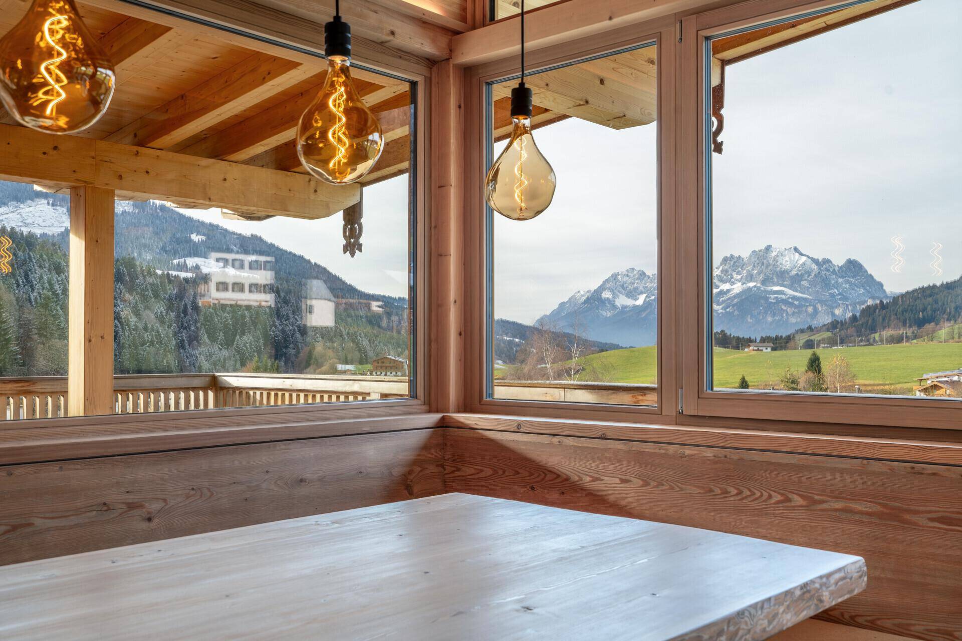 Gemütlicher Essbereich mit Holztisch und Bank, bietet einen malerischen Blick auf die Berge.