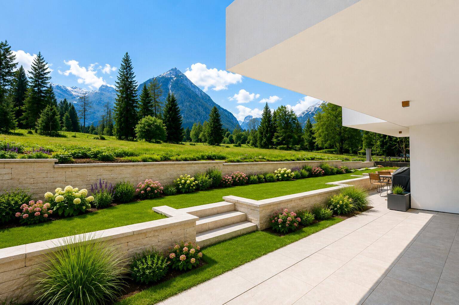 Gepflegter Gartenbereich mit Terrassenstufen, Blumenbeeten und weitem Blick auf die Berge.