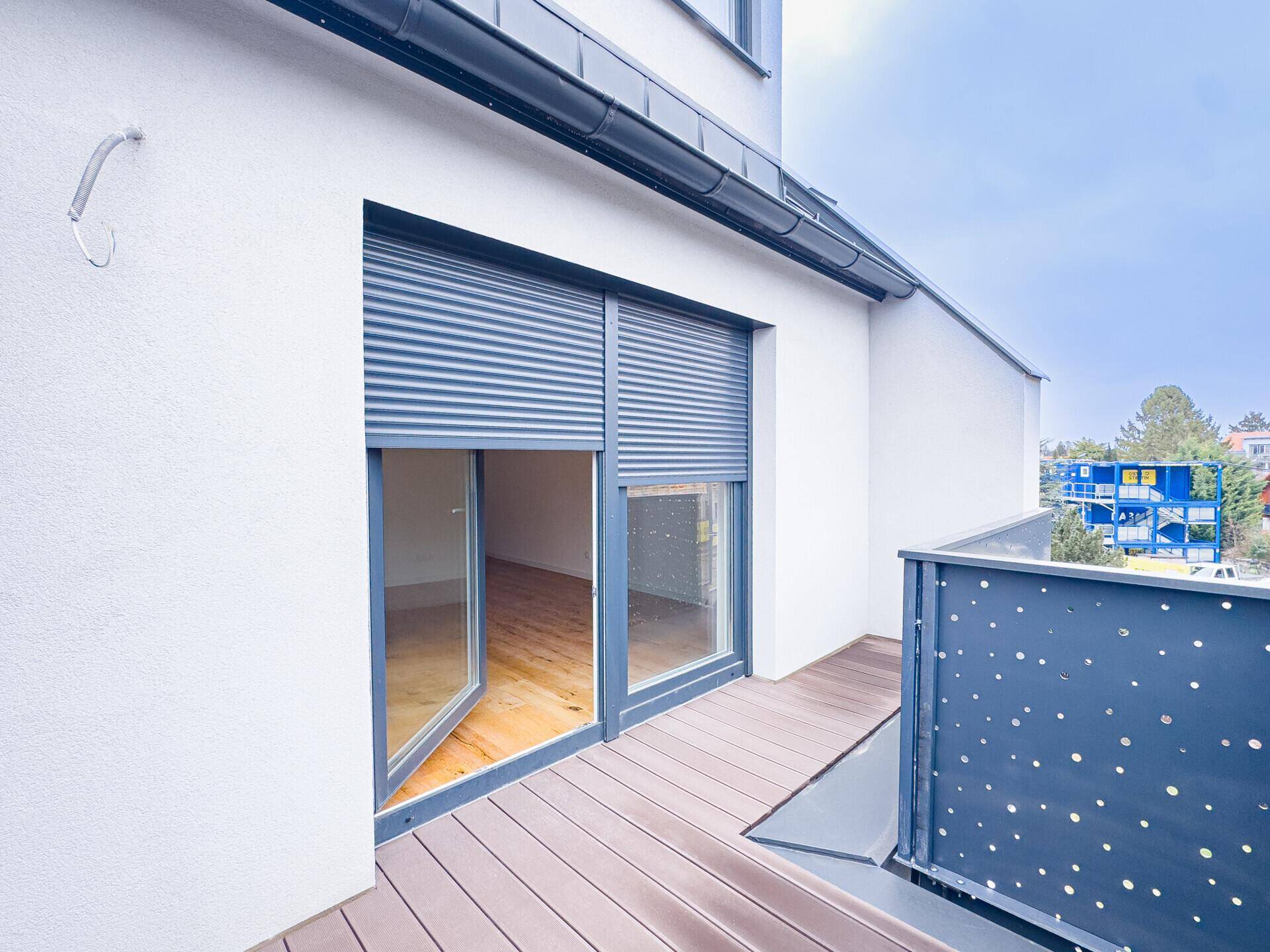 Außenansicht der Terrasse mit Zugang zum Innenbereich und moderner Brüstung.