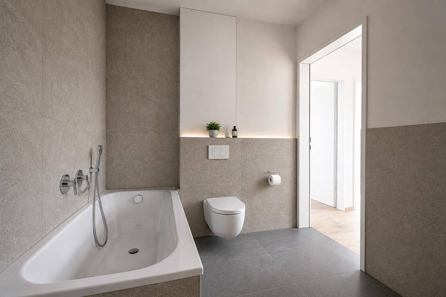 Modernes Badezimmer mit Badewanne, Wand-WC und eleganten grauen Fliesen an Wänden und Boden.