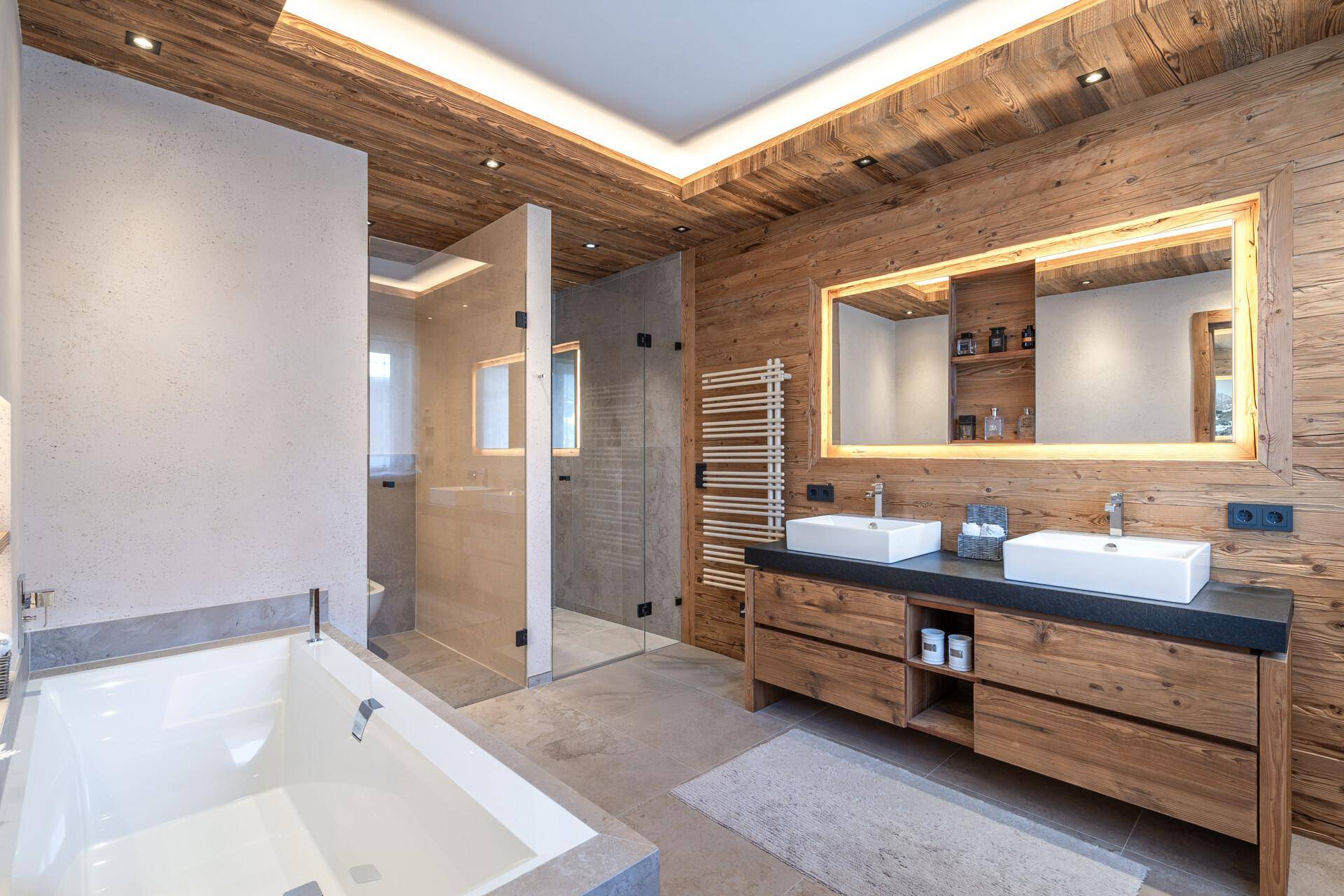 Modernes Badezimmer mit Doppelwaschbecken, Badewanne und begehbarer Dusche im alpinen Stil.