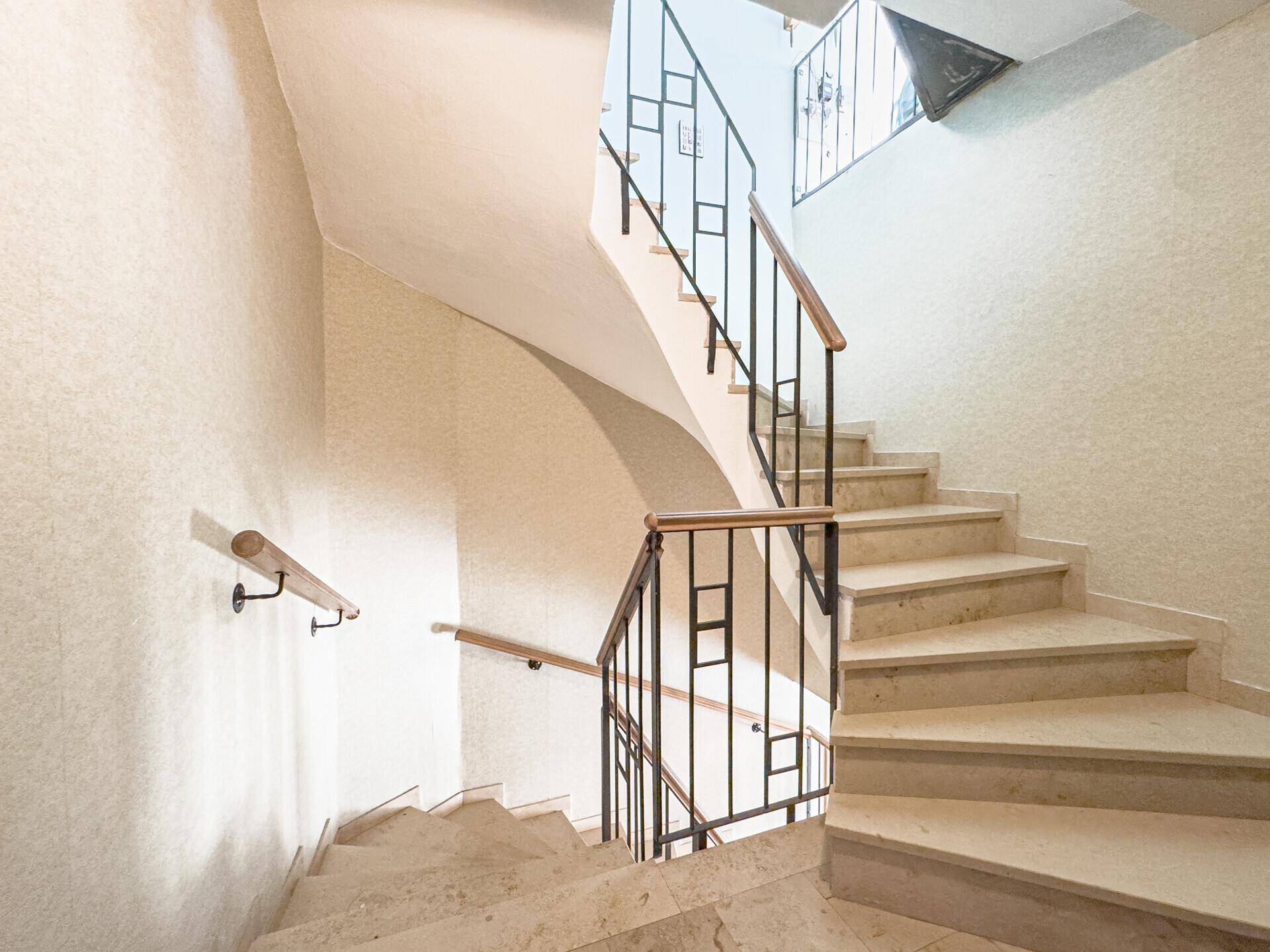 Elegante Treppe mit Marmorstufen und einem schmiedeeisernen Geländer.
