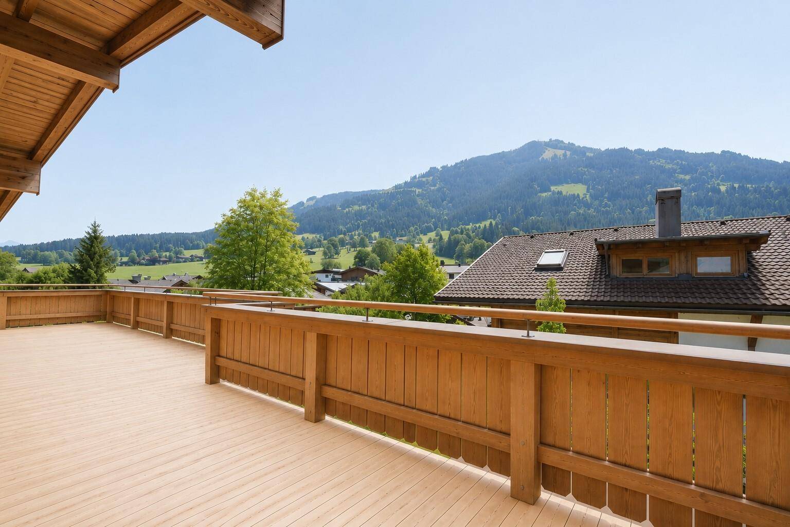 Geräumige Holzterrasse mit Bergblick und viel Platz für eine gemütliche Sitzecke.