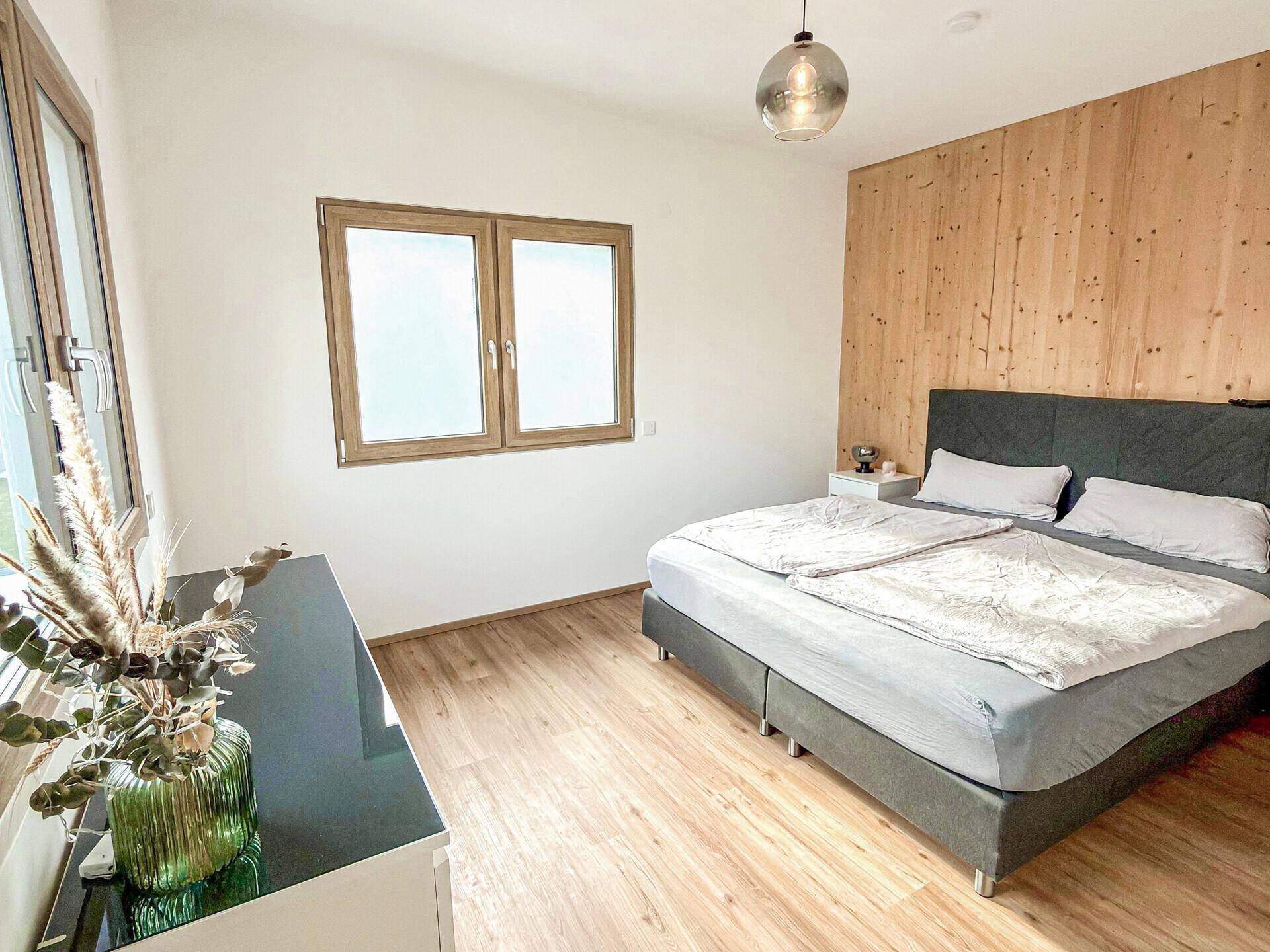 Gemütliches Schlafzimmer mit Holzboden, Holzdecke und großem Doppelbett, hell und einladend gestaltet.