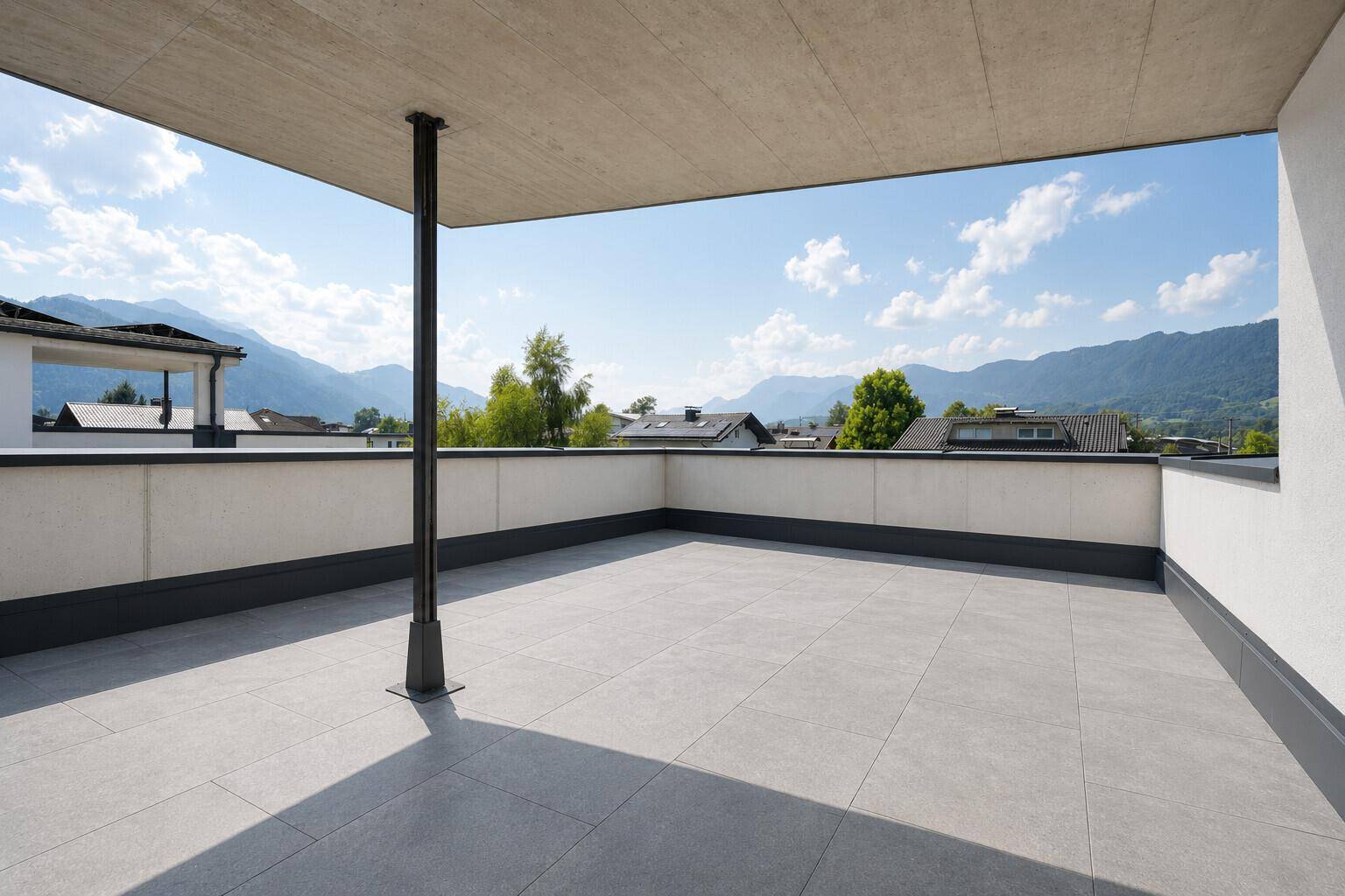 Große, geflieste Terrasse mit Überdachung und Panoramablick auf die umliegende Bergwelt.