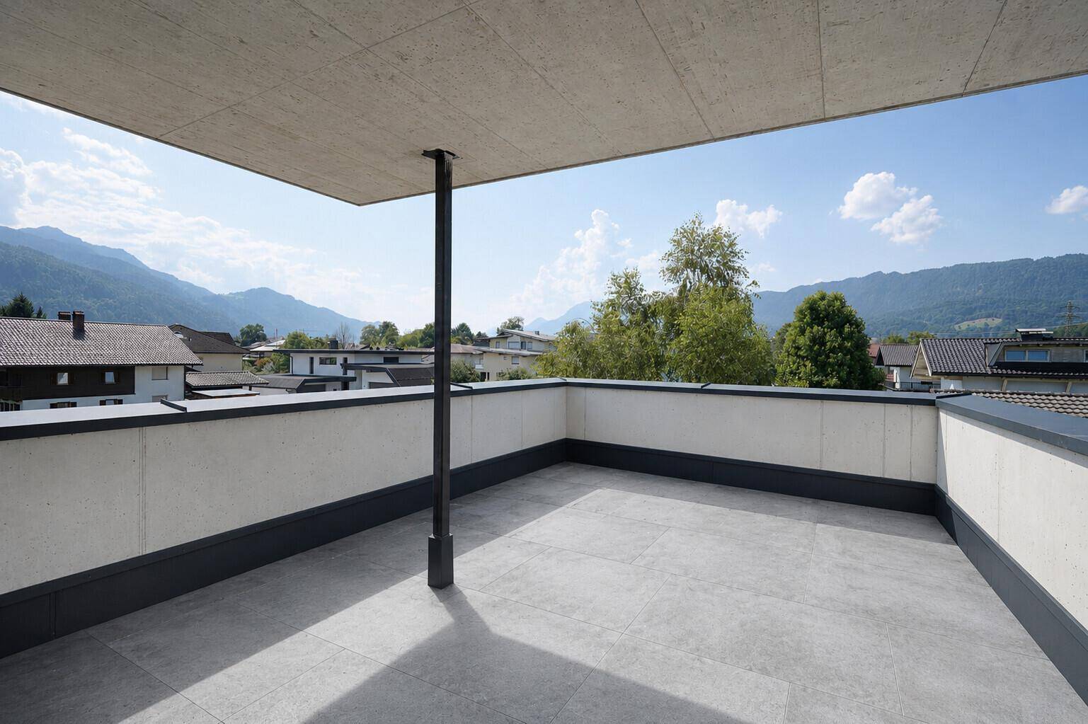 Helle Dachterrasse mit teilweiser Überdachung und beeindruckendem Panoramablick auf die Berge.