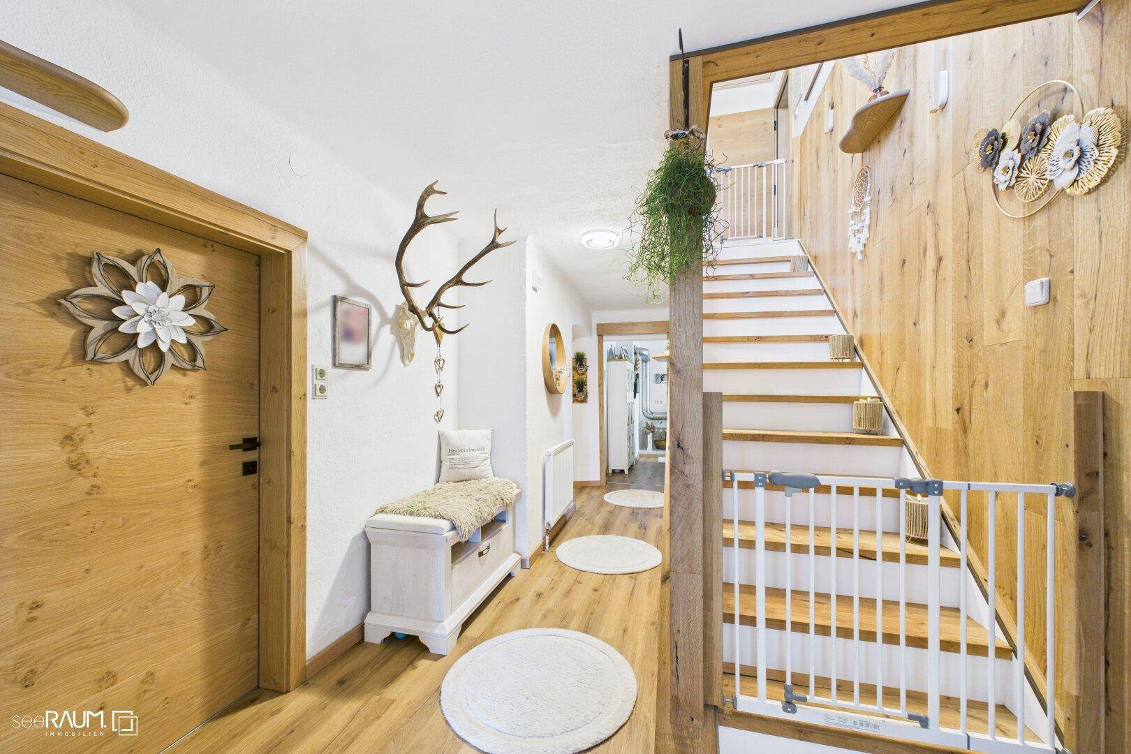 Heller Flur mit Holzvertäfelung, Treppe und alpiner Dekoration.