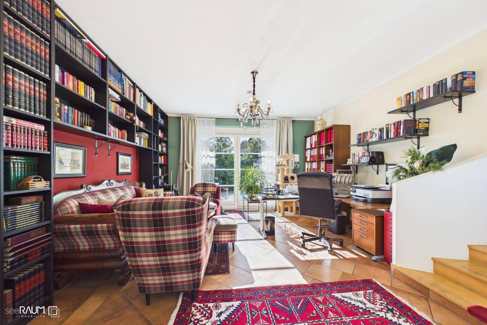 Großzügiges Arbeitszimmer mit Bücherregalen, Terrakottaboden und Gartenzugang.