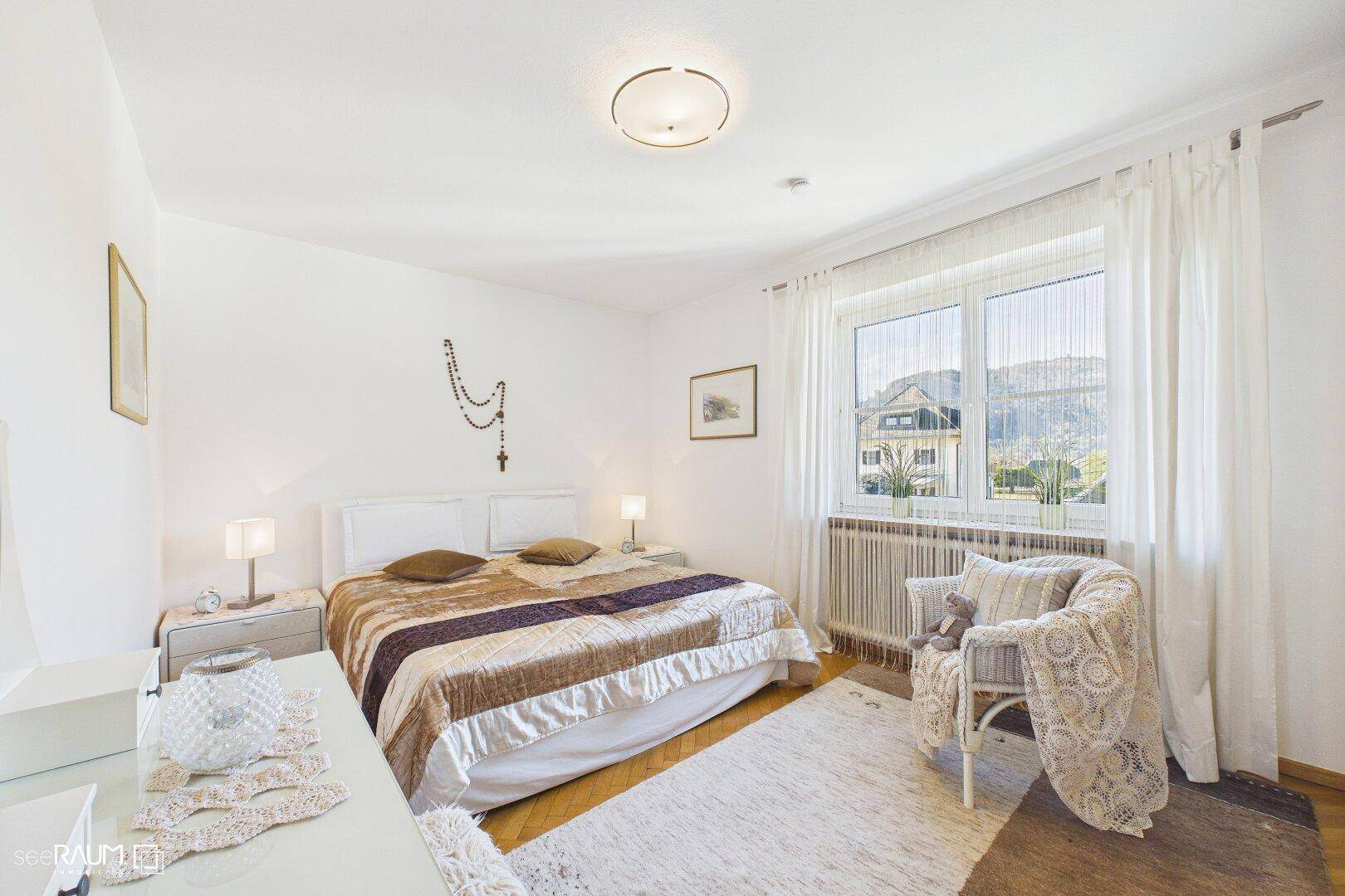 Ruhiges Schlafzimmer mit Doppelbett, Holzboden und weitem Blick in die Natur.